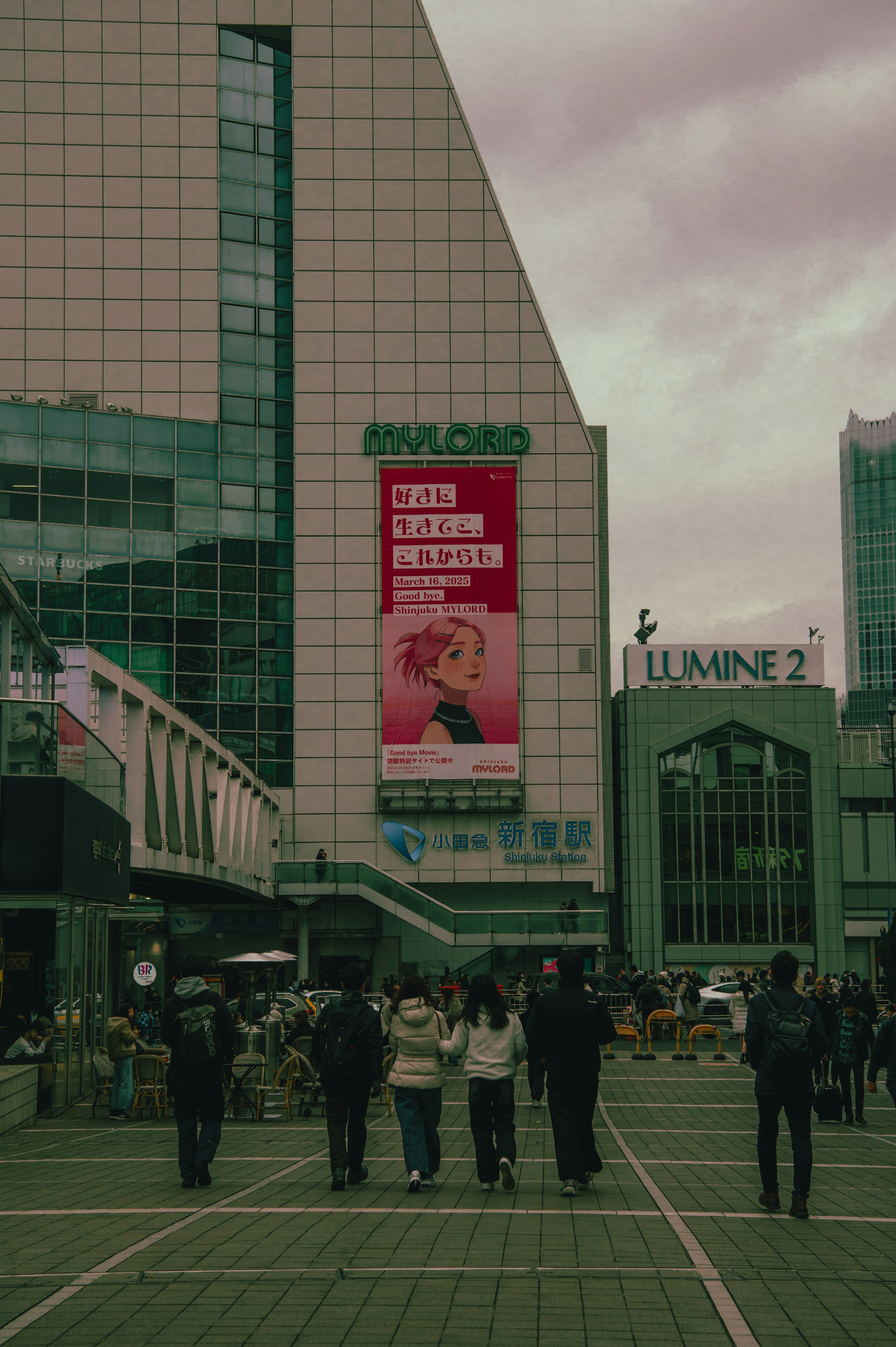 Foule de personnes dans une place urbaine animée avec une grande publicité