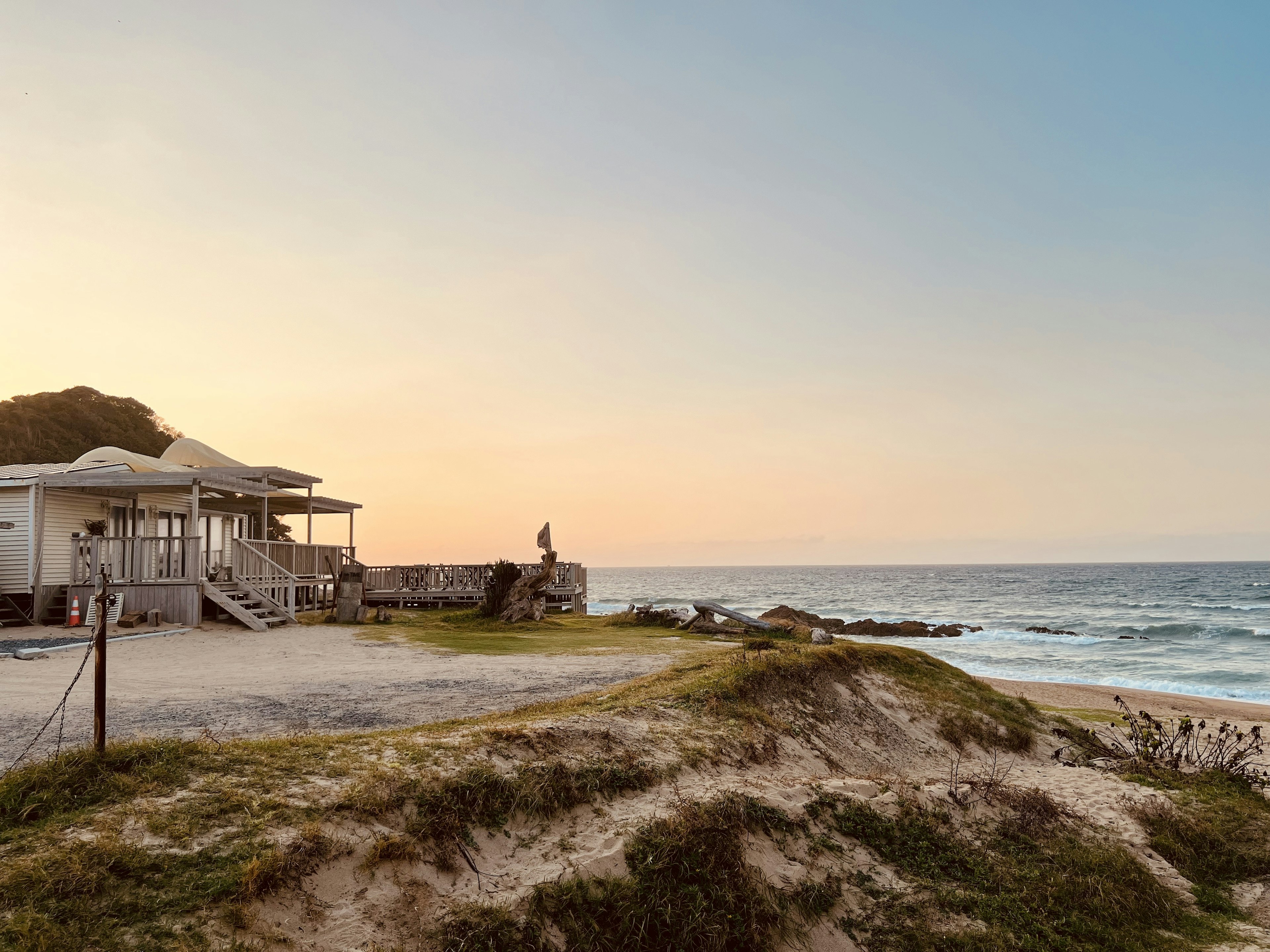 Küstenhaus mit Sonnenuntergang über dem Ozean