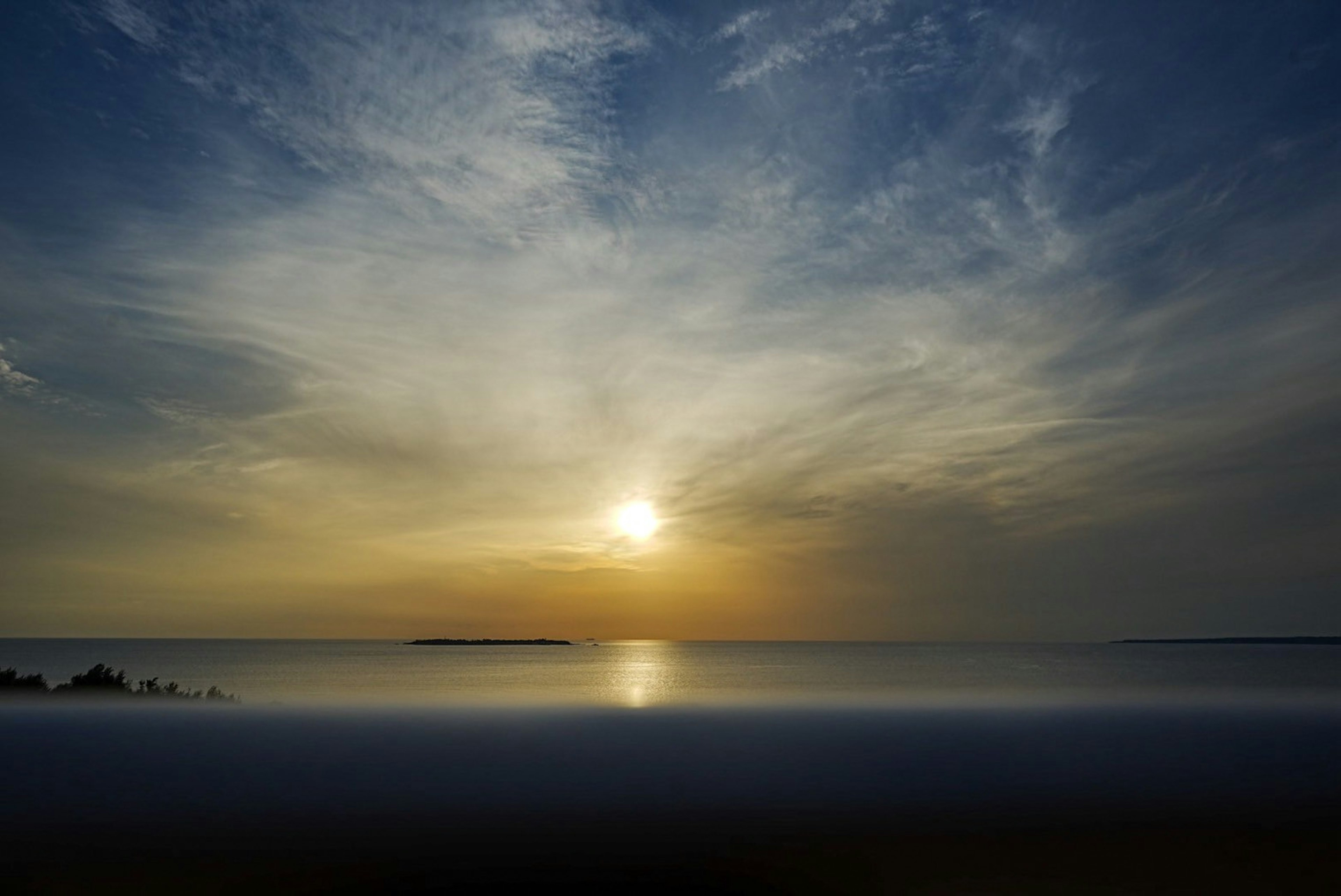 Schöner Sonnenuntergang über dem Ozean mit blauem Himmel und Wolken