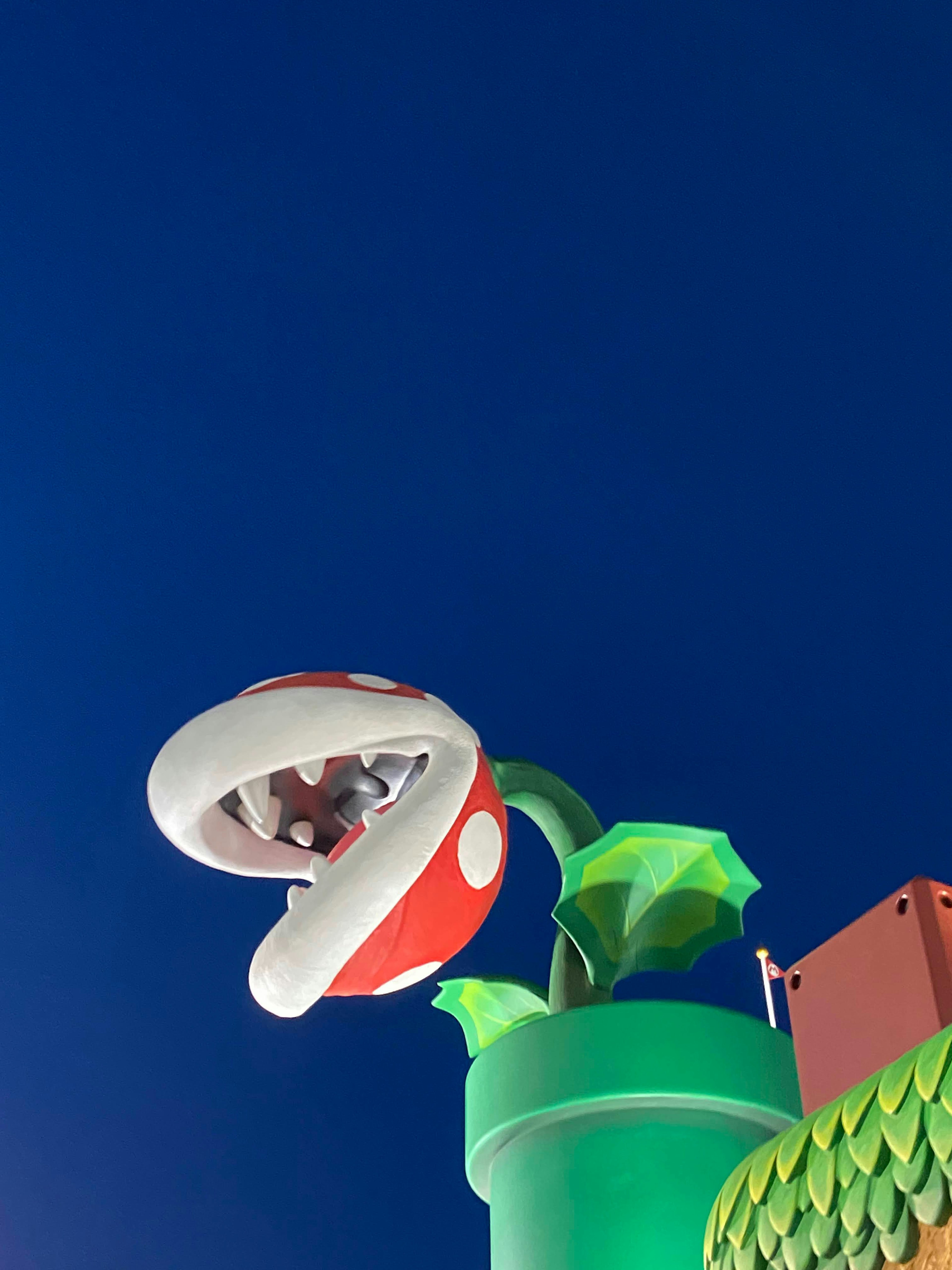 Imagen de un gran personaje de planta piranha de Mario con fondo de cielo azul