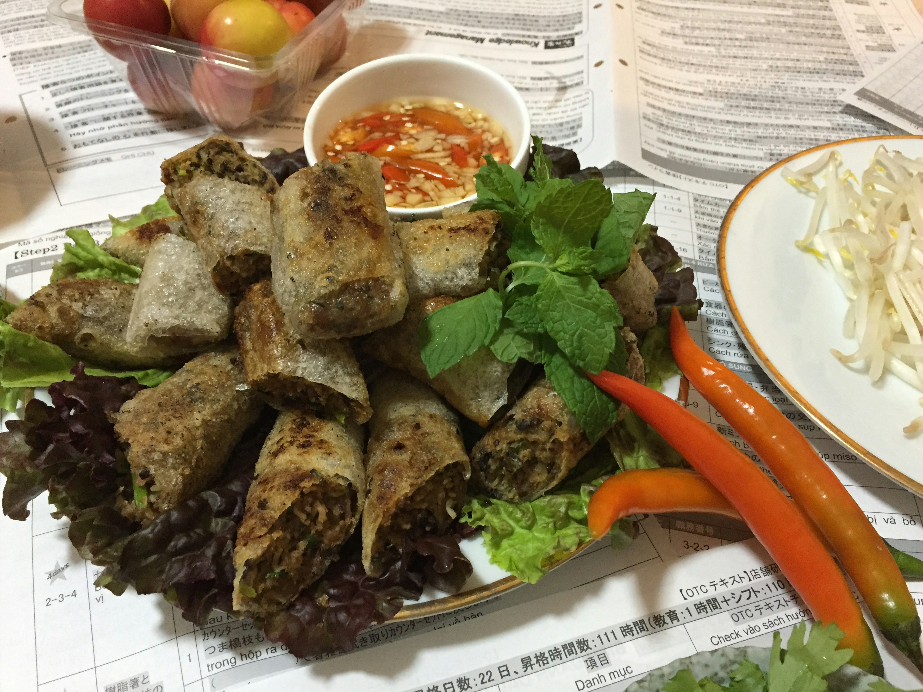 Piring lumpia goreng dihiasi dengan herbal segar