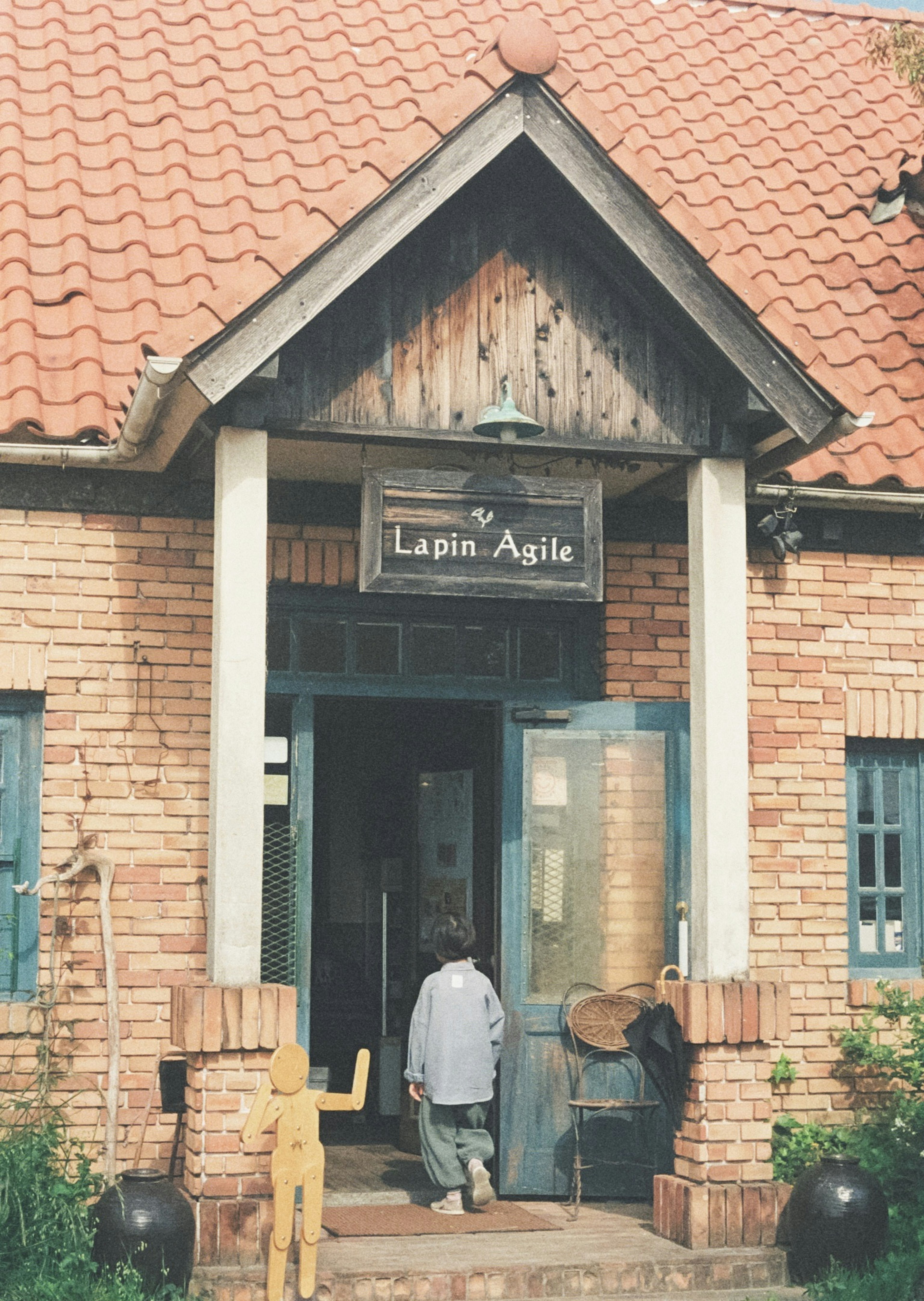 Entrance of a brick building with a sign reading Lapin Agile