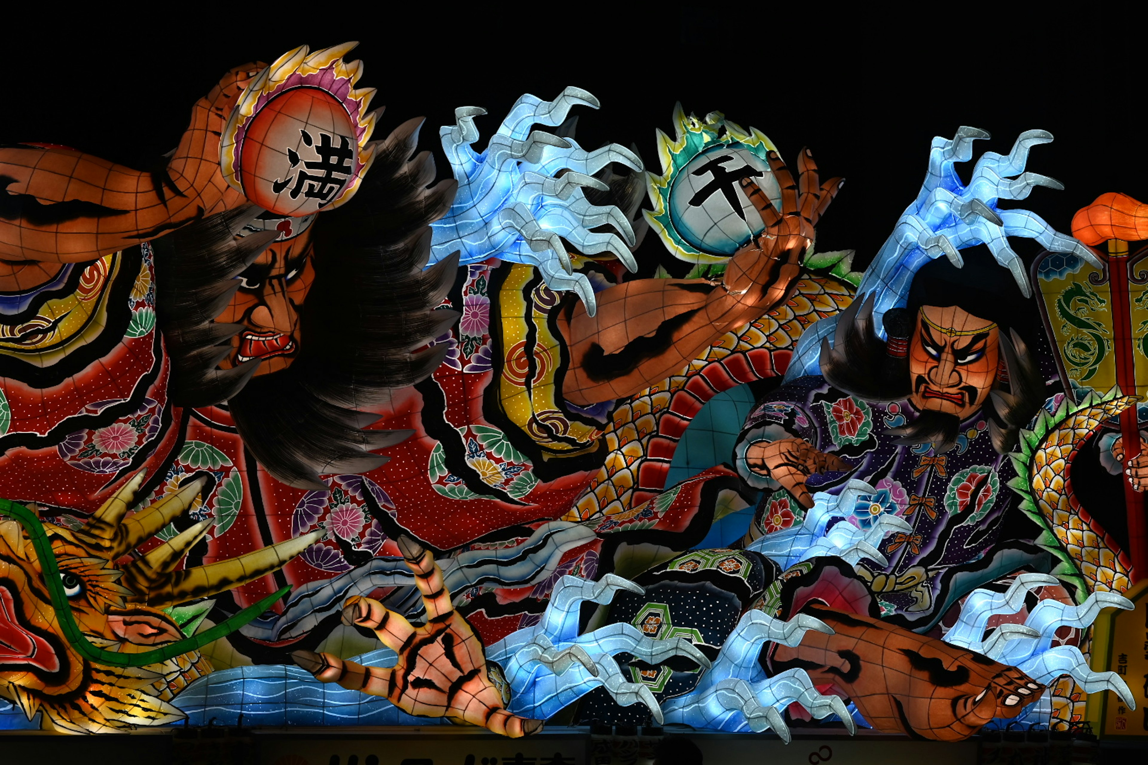 Vibrant traditional Japanese Nebuta festival float depicting fierce warriors and gods with splashing water