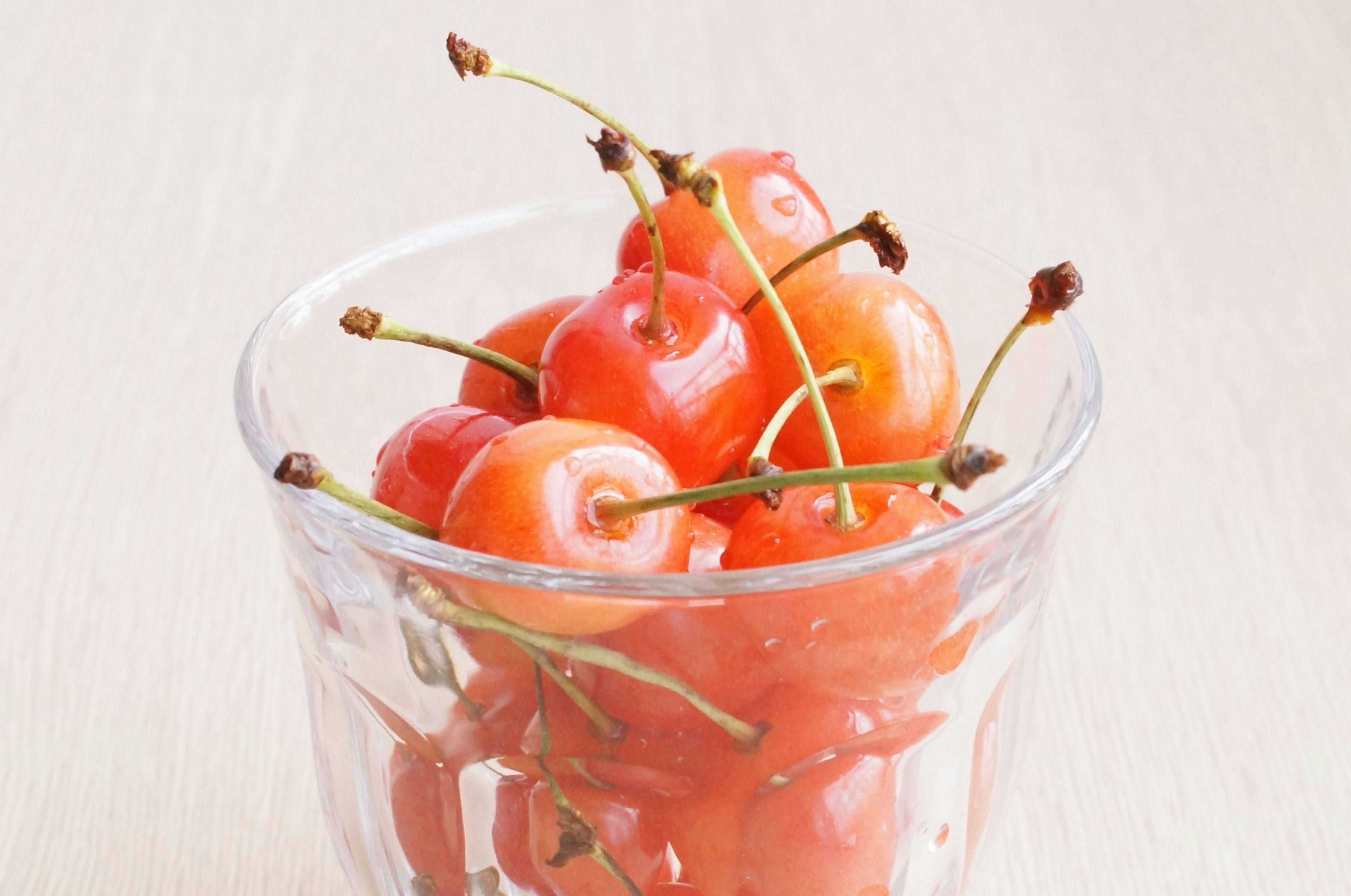 Cerezas rojas en un tazón de vidrio transparente