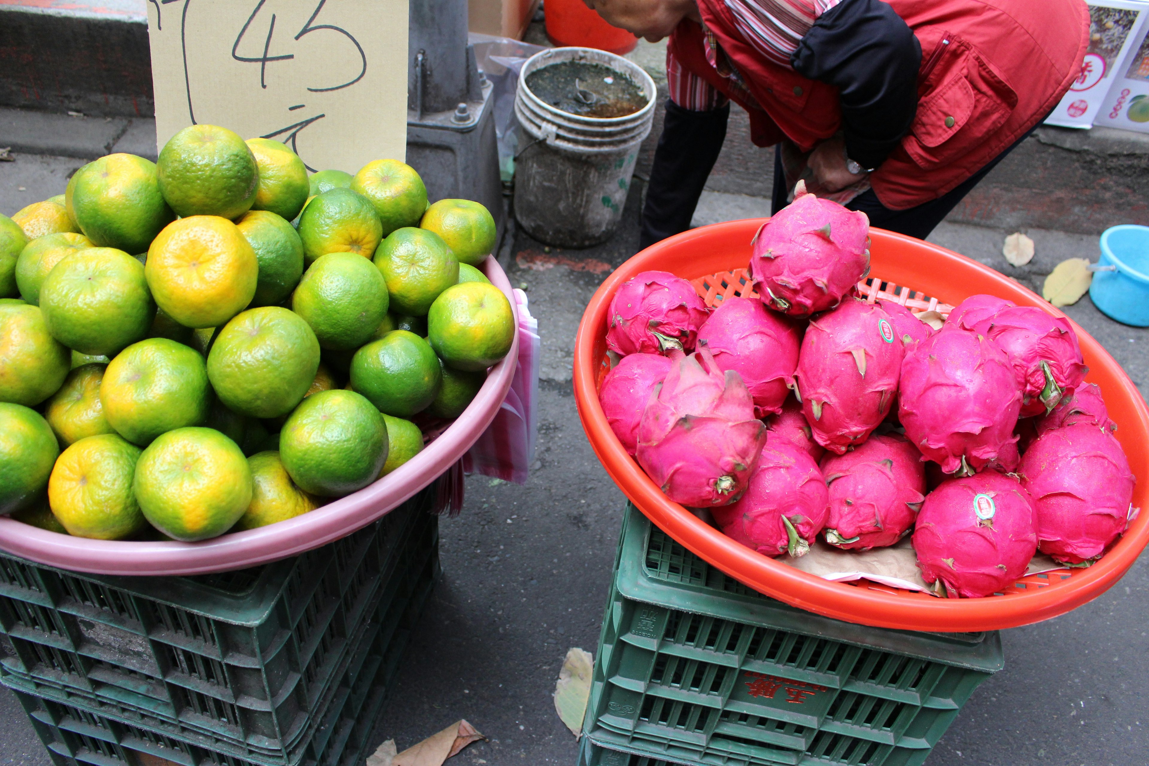 Paniers d'oranges et de fruit du dragon dans un marché