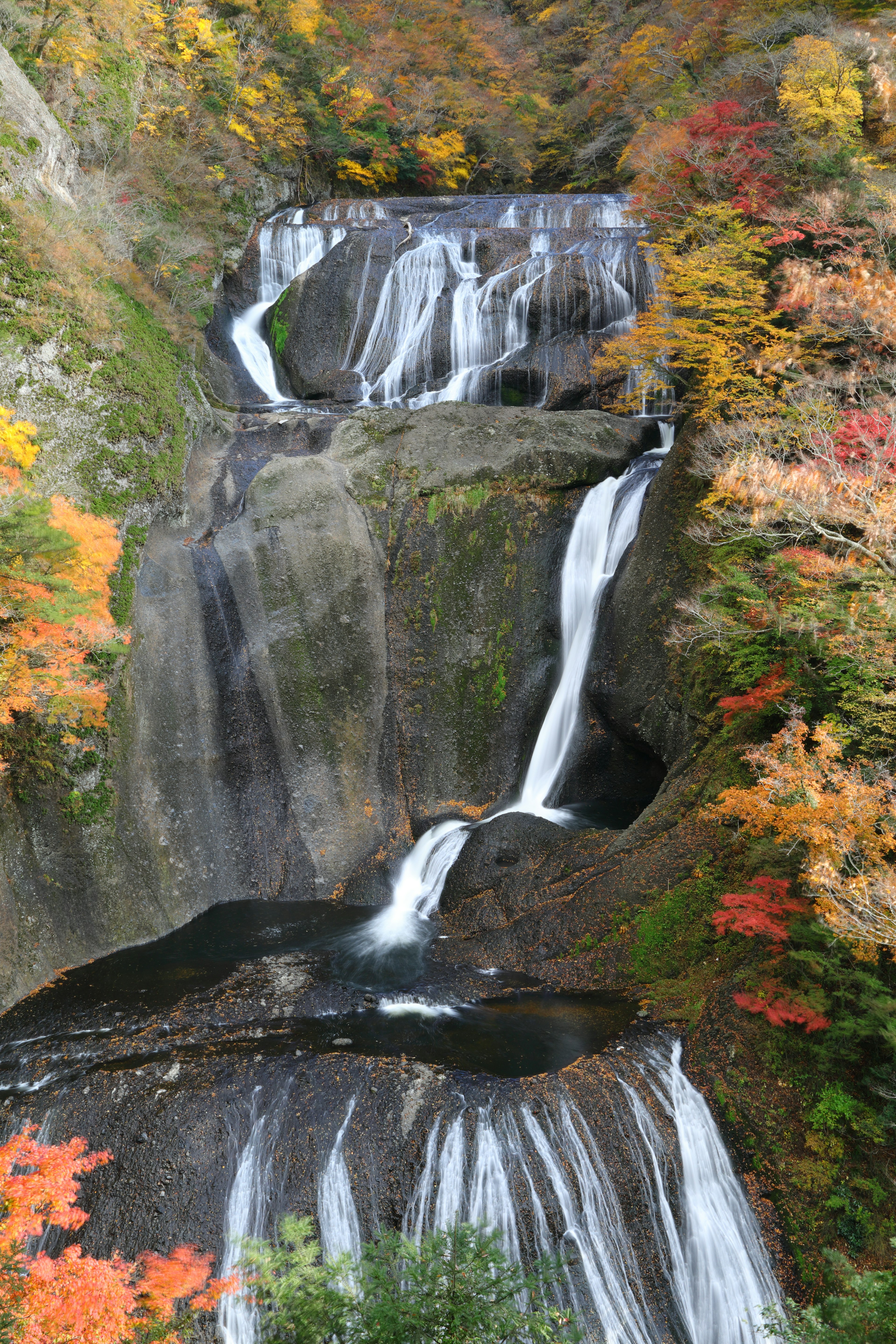 ทิวทัศน์ที่สวยงามของน้ำตกที่รายล้อมไปด้วยใบไม้ฤดูใบไม้ร่วงที่มีสีสัน