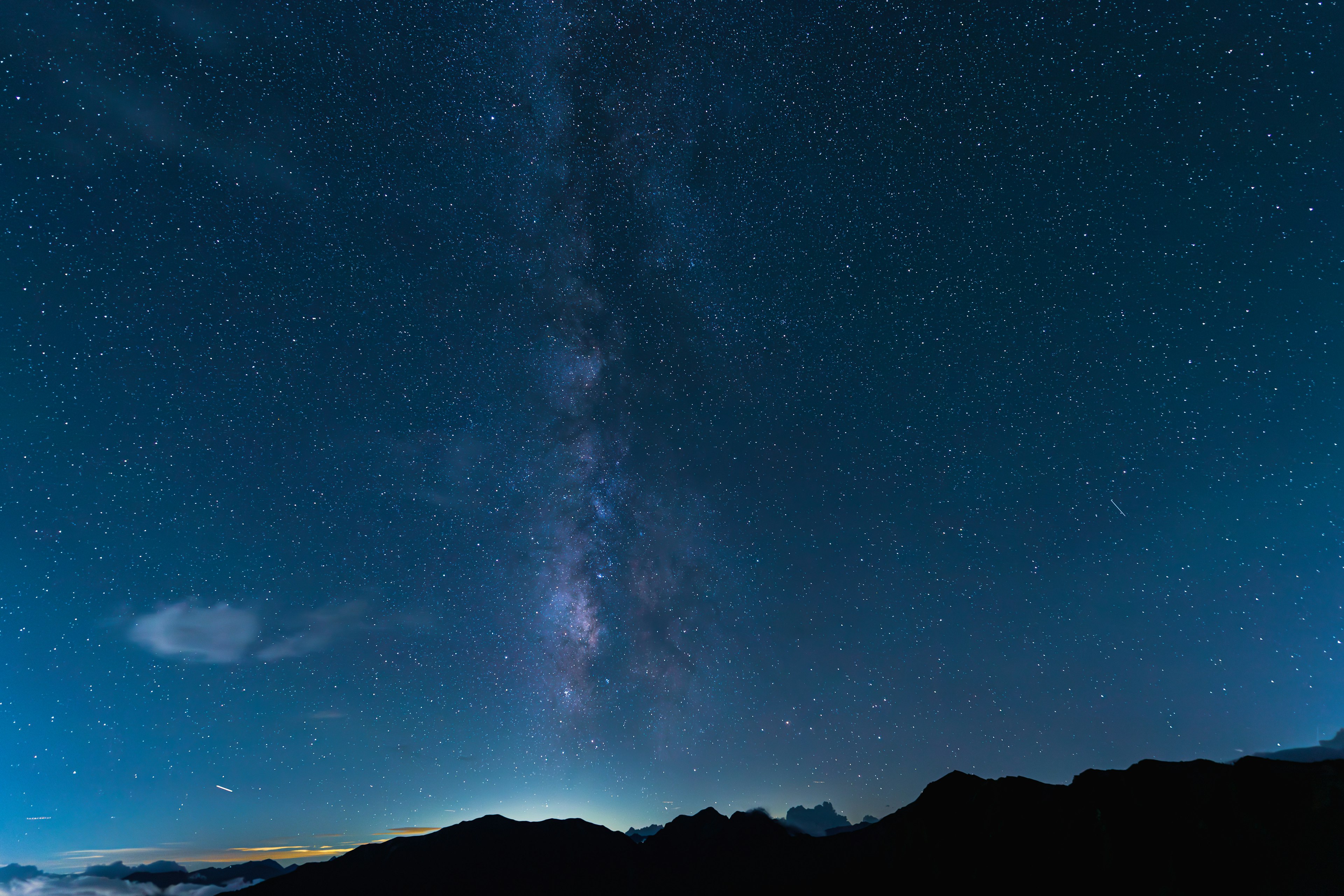 Vista mozzafiato del cielo stellato e della Via Lattea con silhouette montane