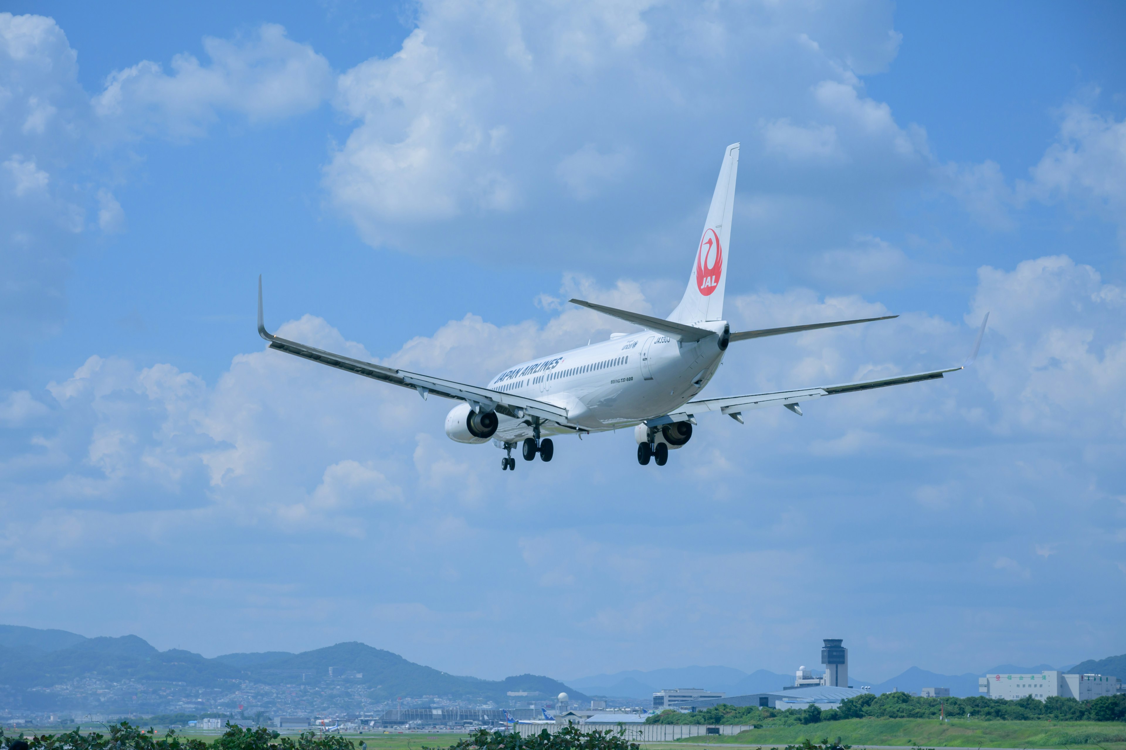 An airplane landing against a blue sky