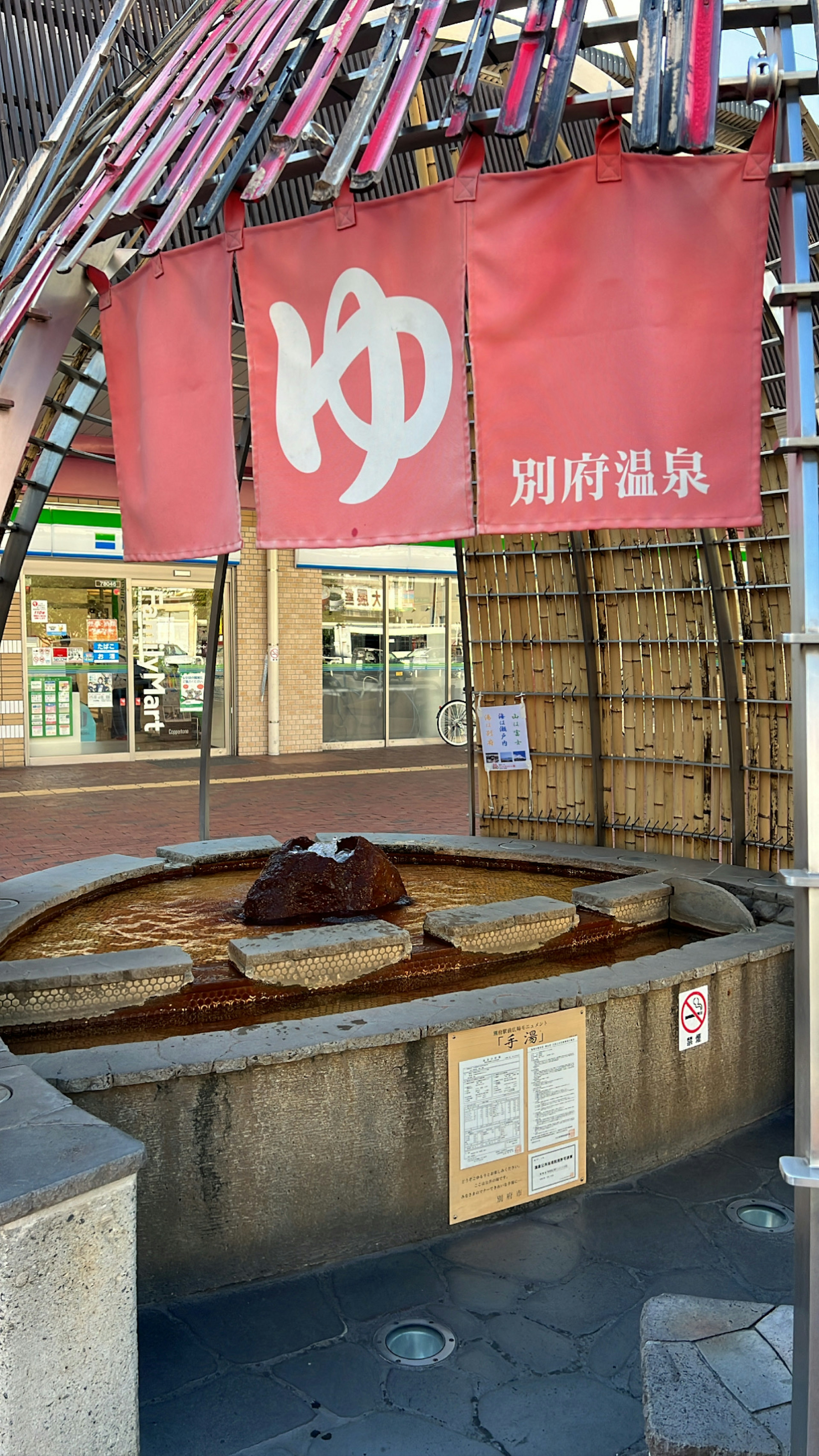 Outdoor hot spring feature with a red banner indicating hot water