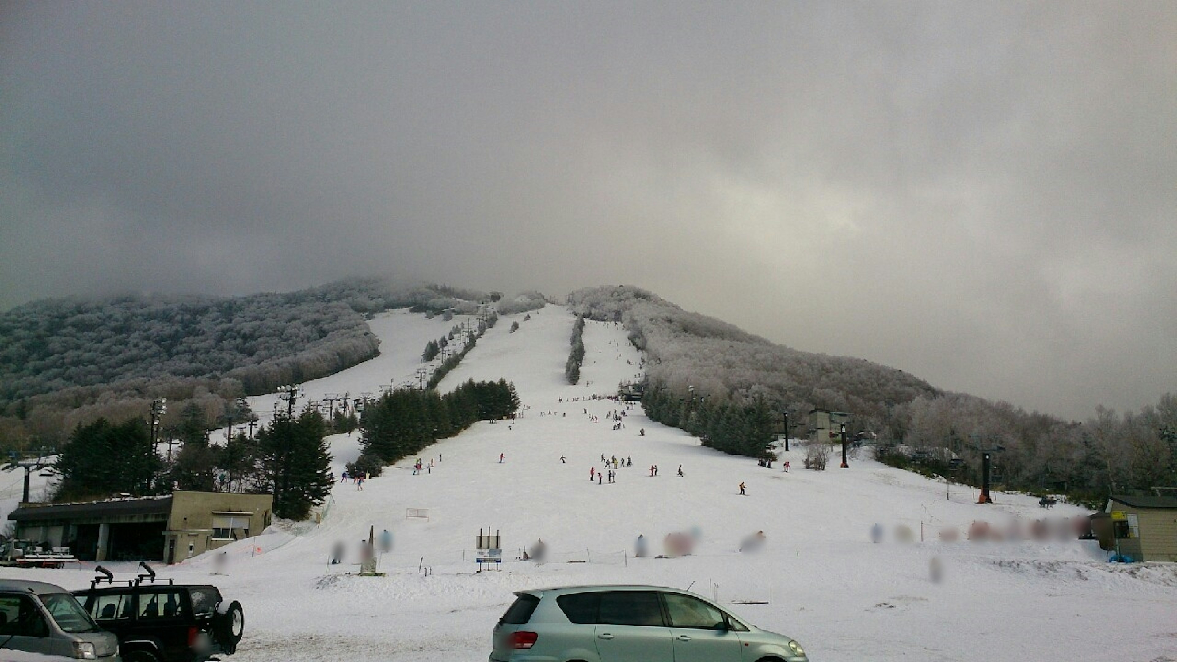 Montagne enneigée avec pistes de ski et ciel nuageux