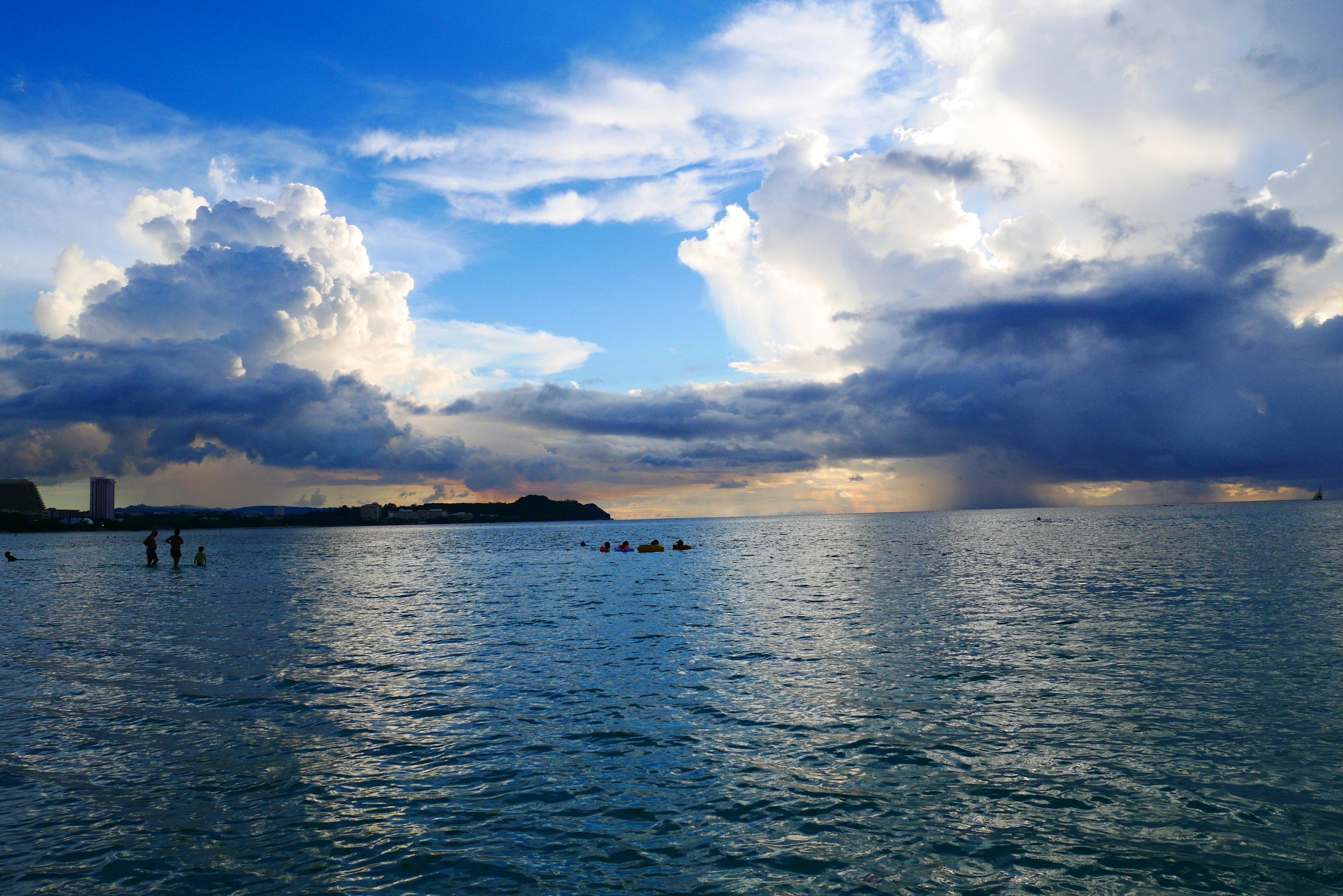 青い海と空の美しい風景に浮かぶ雲と人々