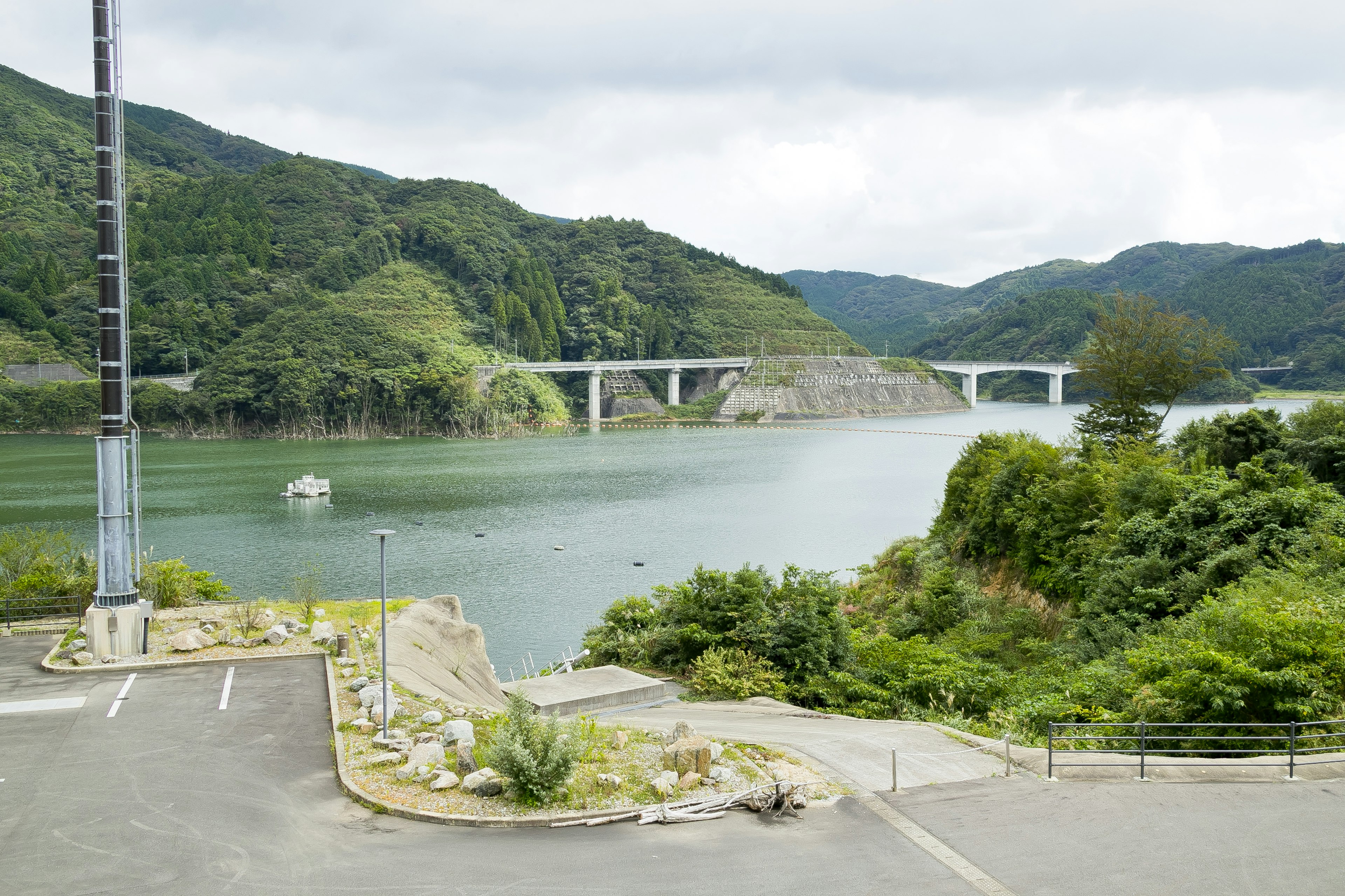 湖と橋を背景にした緑豊かな山々の風景