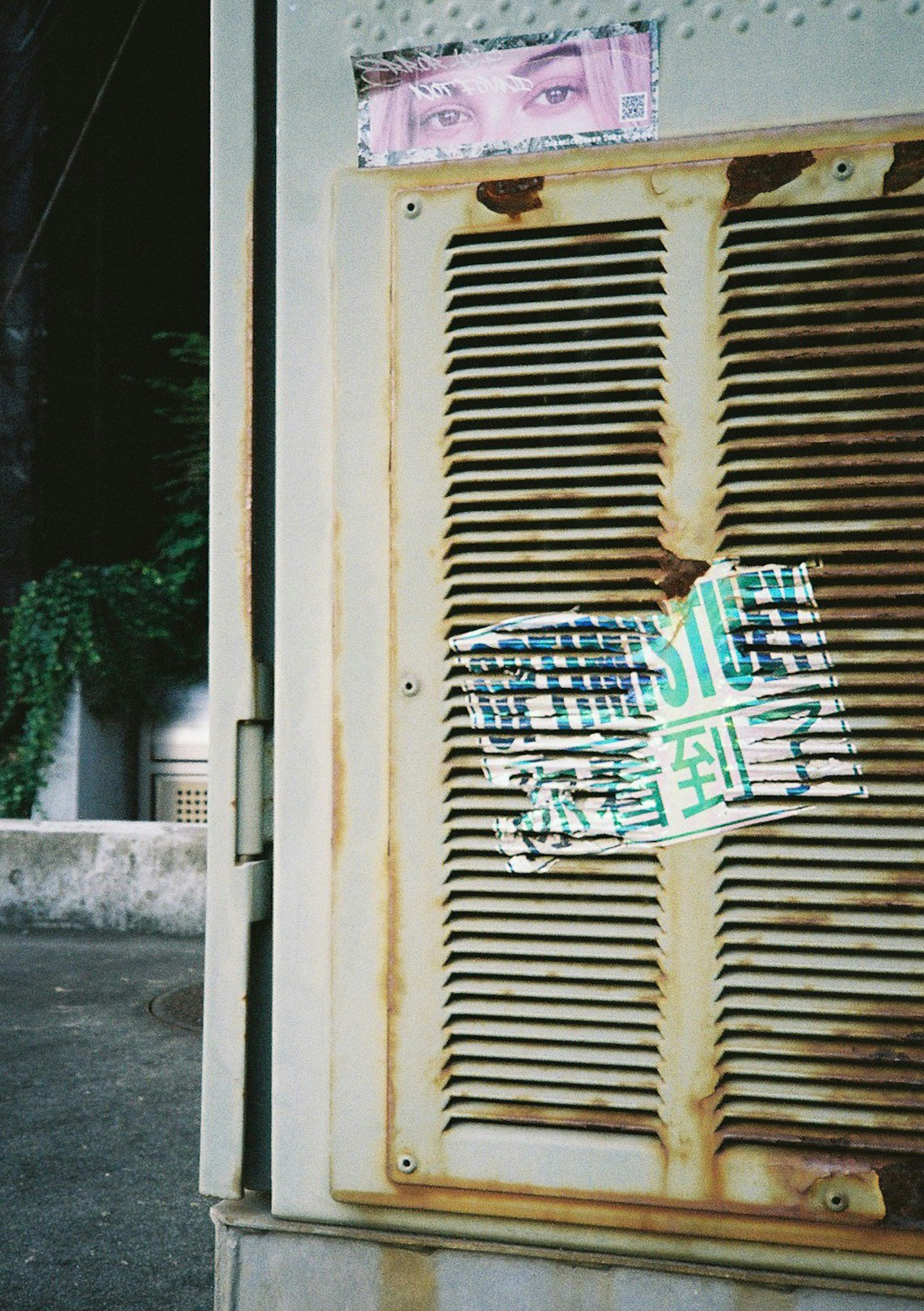 Porte en métal rouillé avec autocollant coloré et yeux visibles