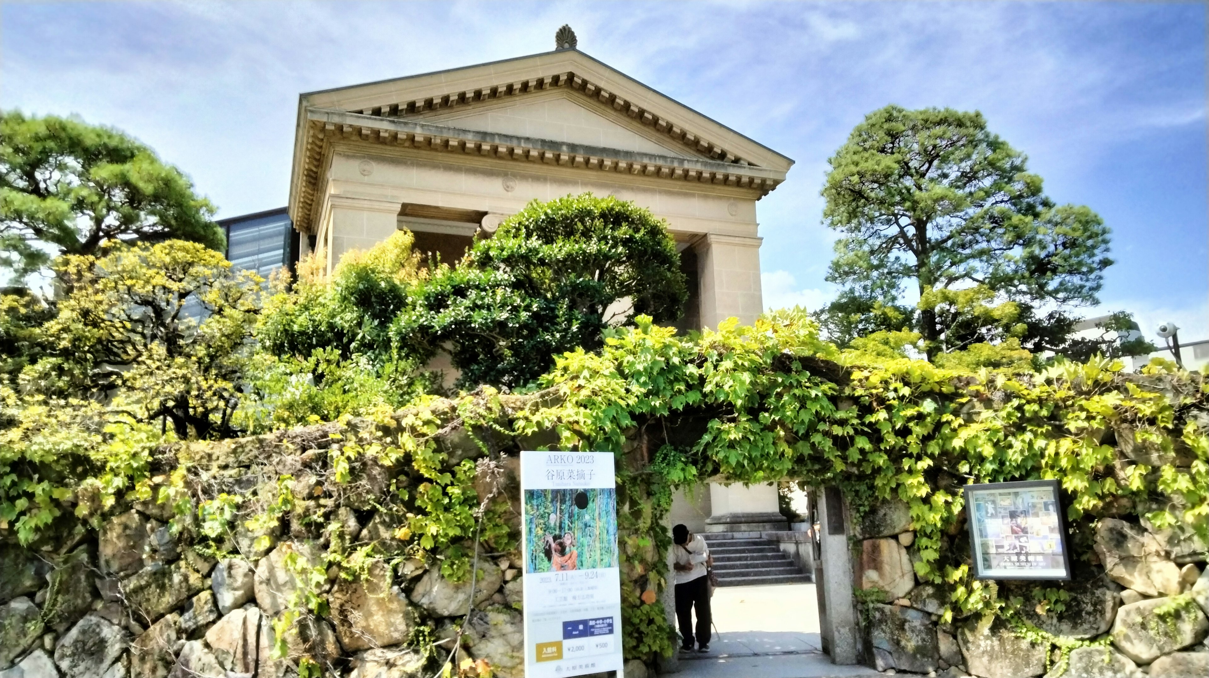 Historic building entrance surrounded by greenery