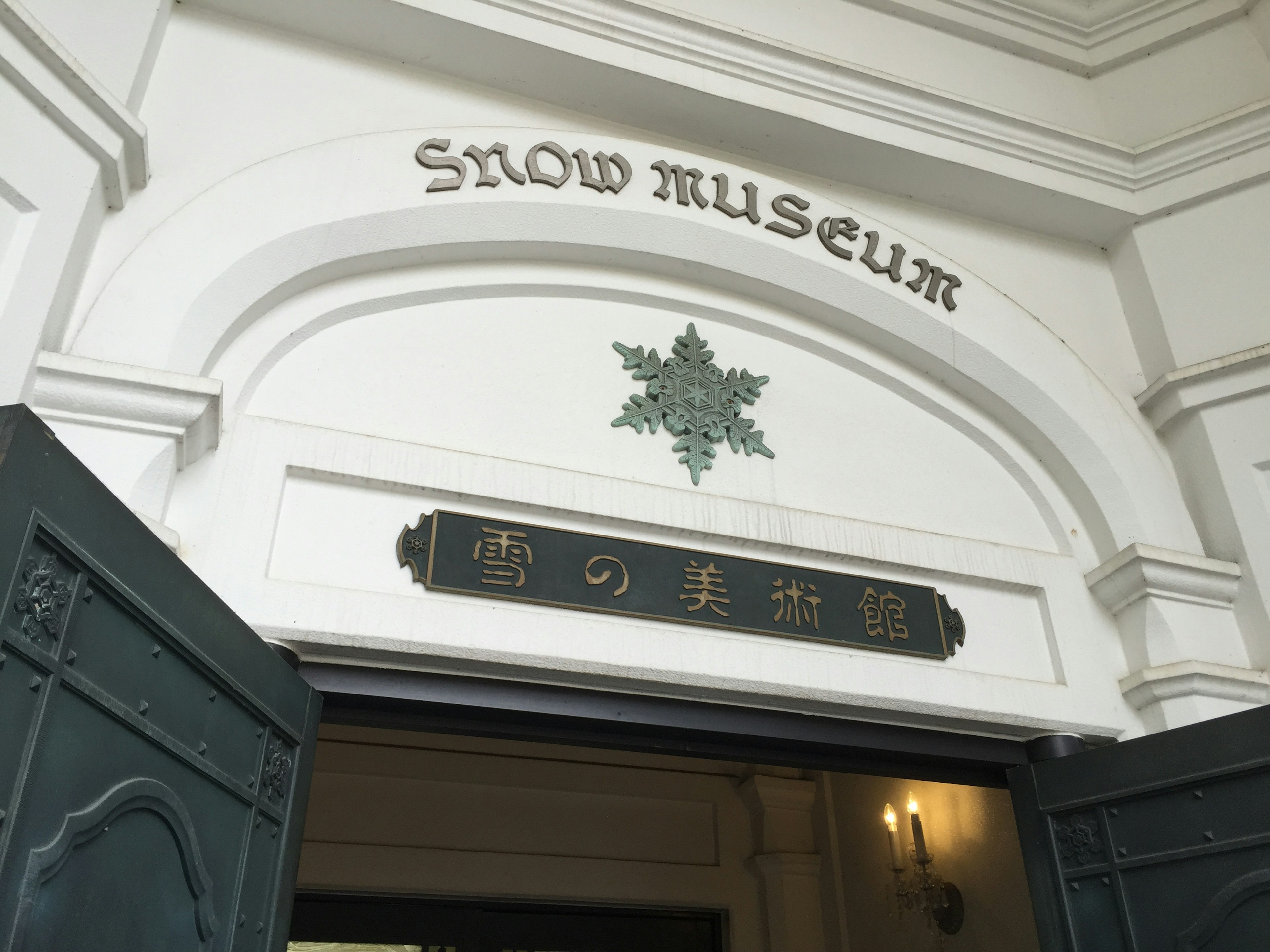 Pintu masuk Museum Salju dengan dekorasi salju dan nama ditampilkan dalam bahasa Inggris dan Jepang