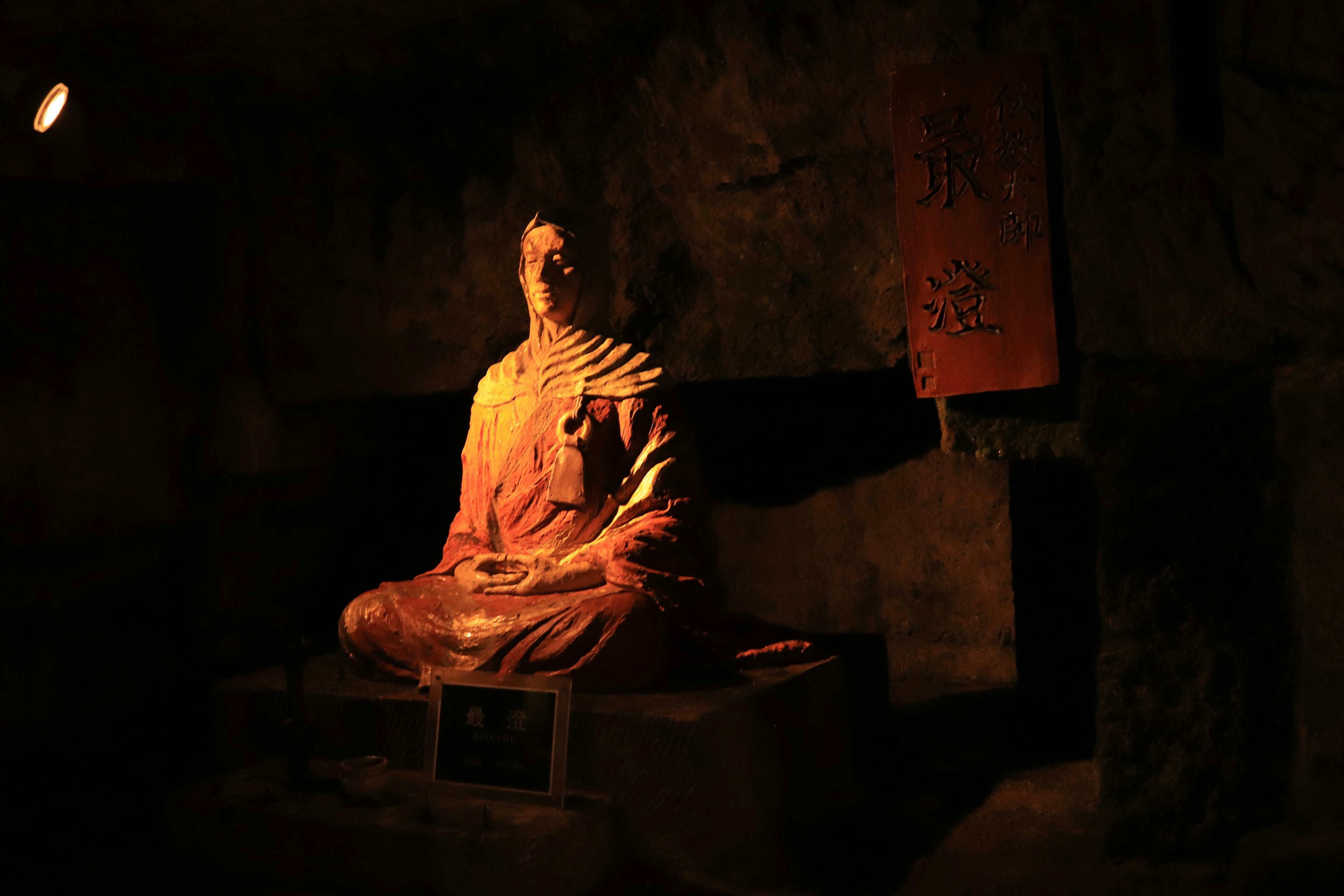 Hermosa escultura de una estatua de Buda sentada en un entorno oscuro con luz suave