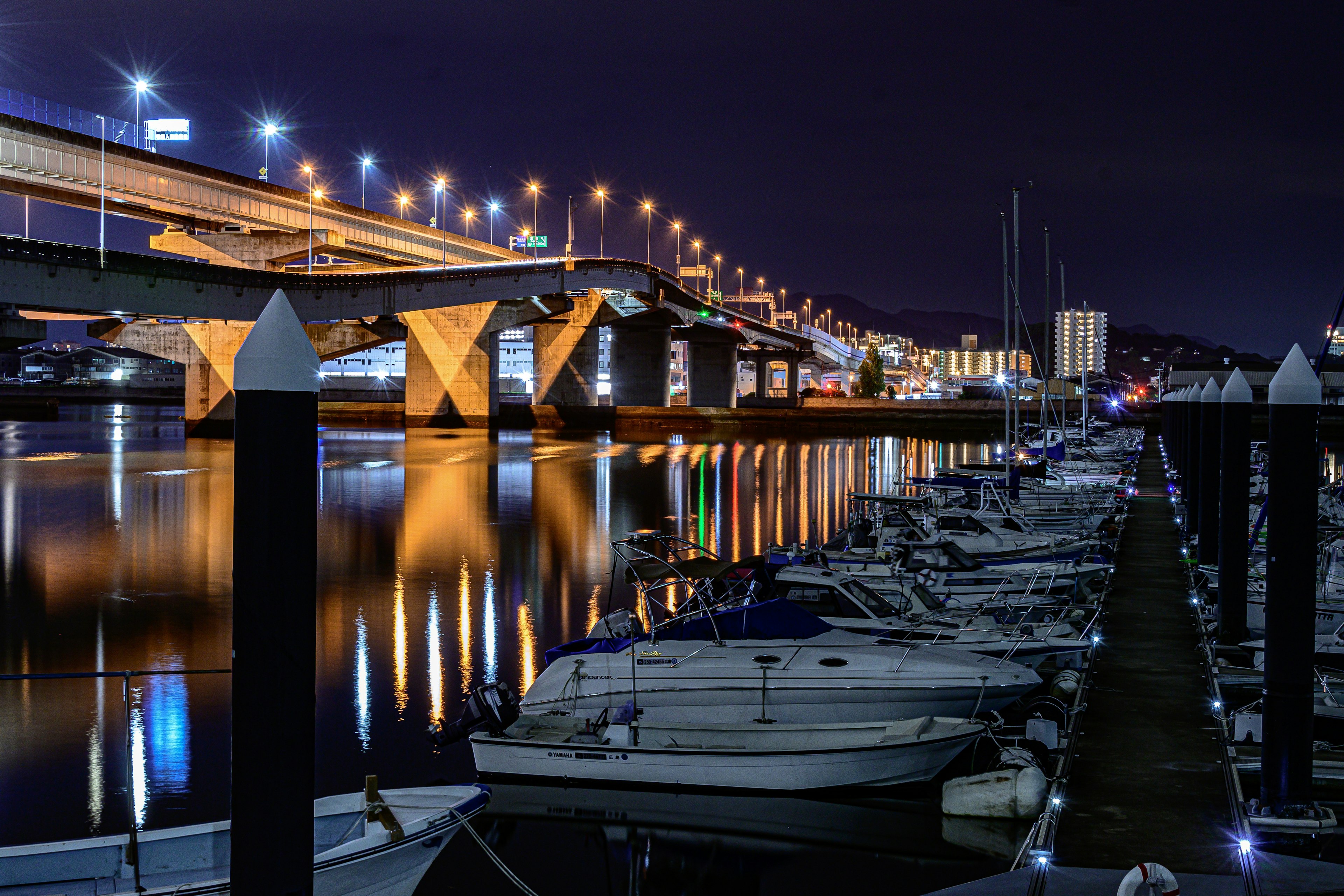 Beautiful reflection of boats and bridge in the night harbor