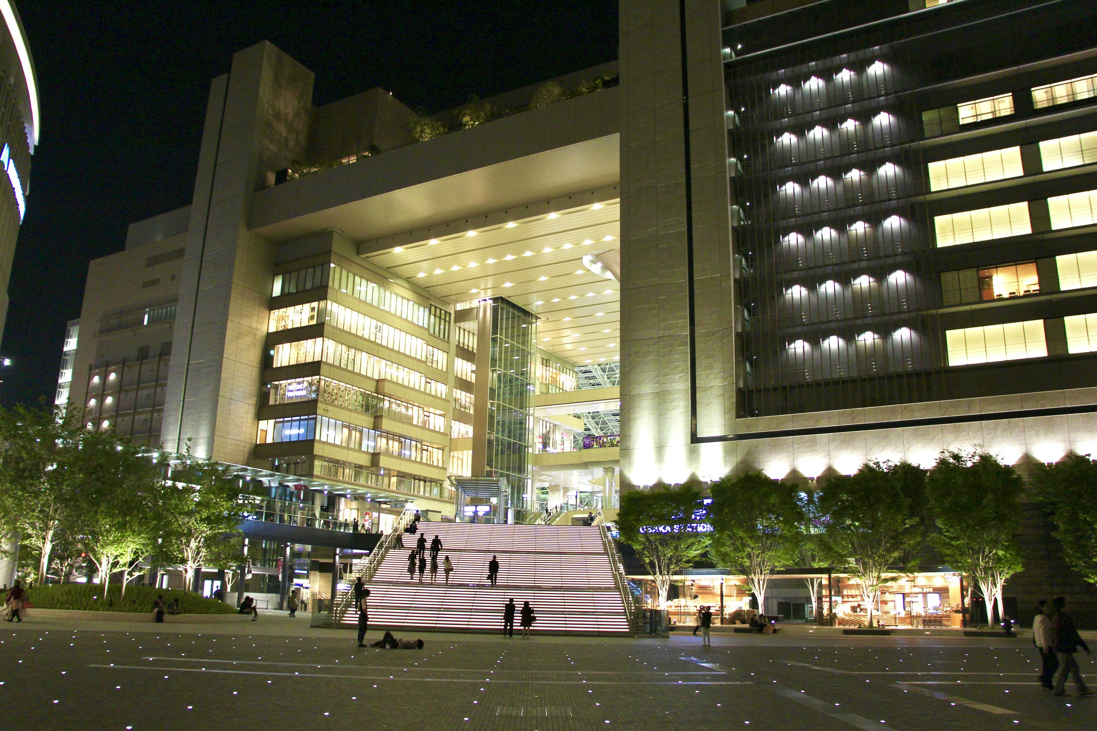 Vue extérieure d'un bâtiment moderne la nuit avec des personnes