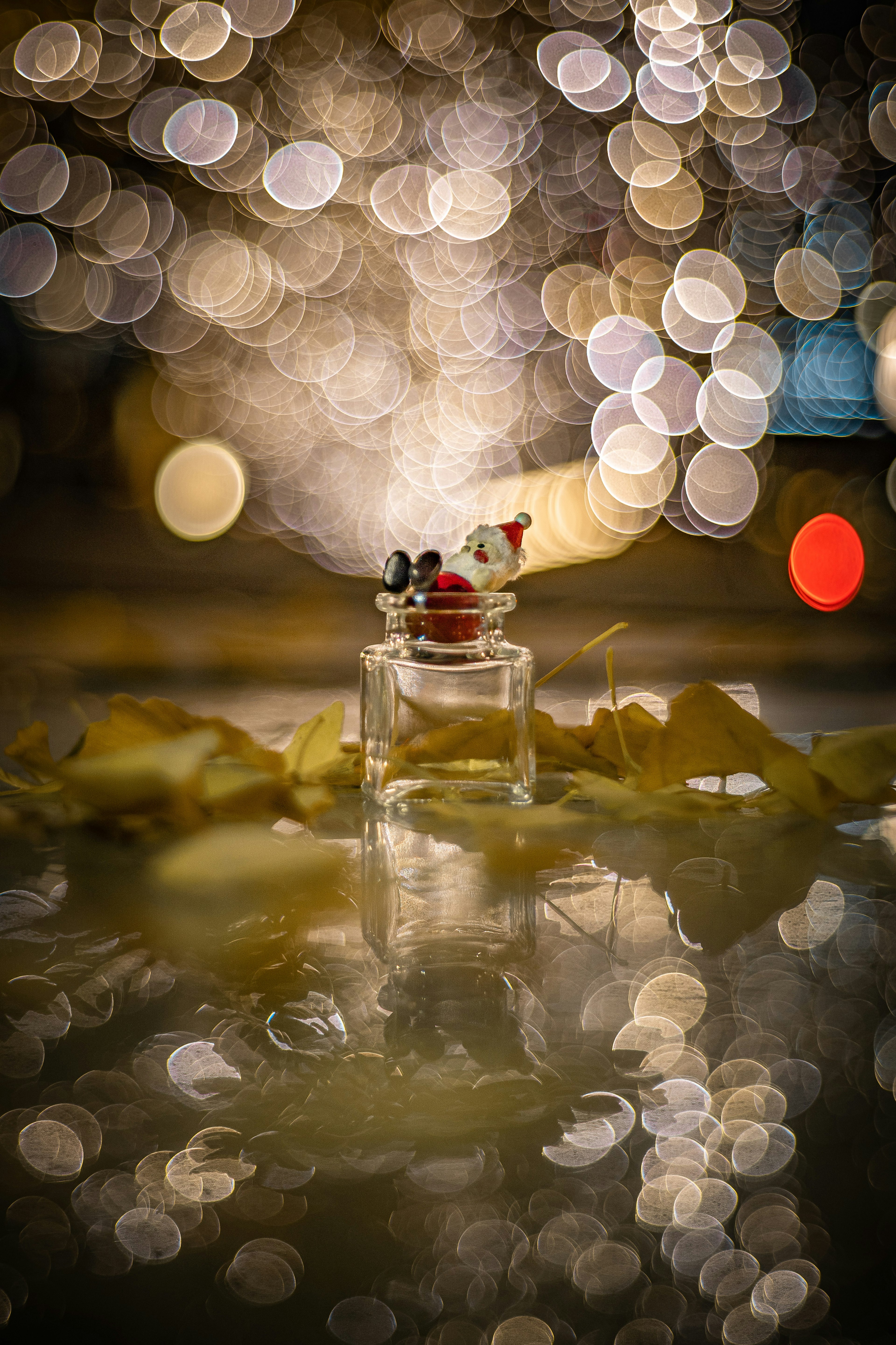 Una pequeña figurita en un frasco de vidrio rodeada de luces circulares borrosas de fondo