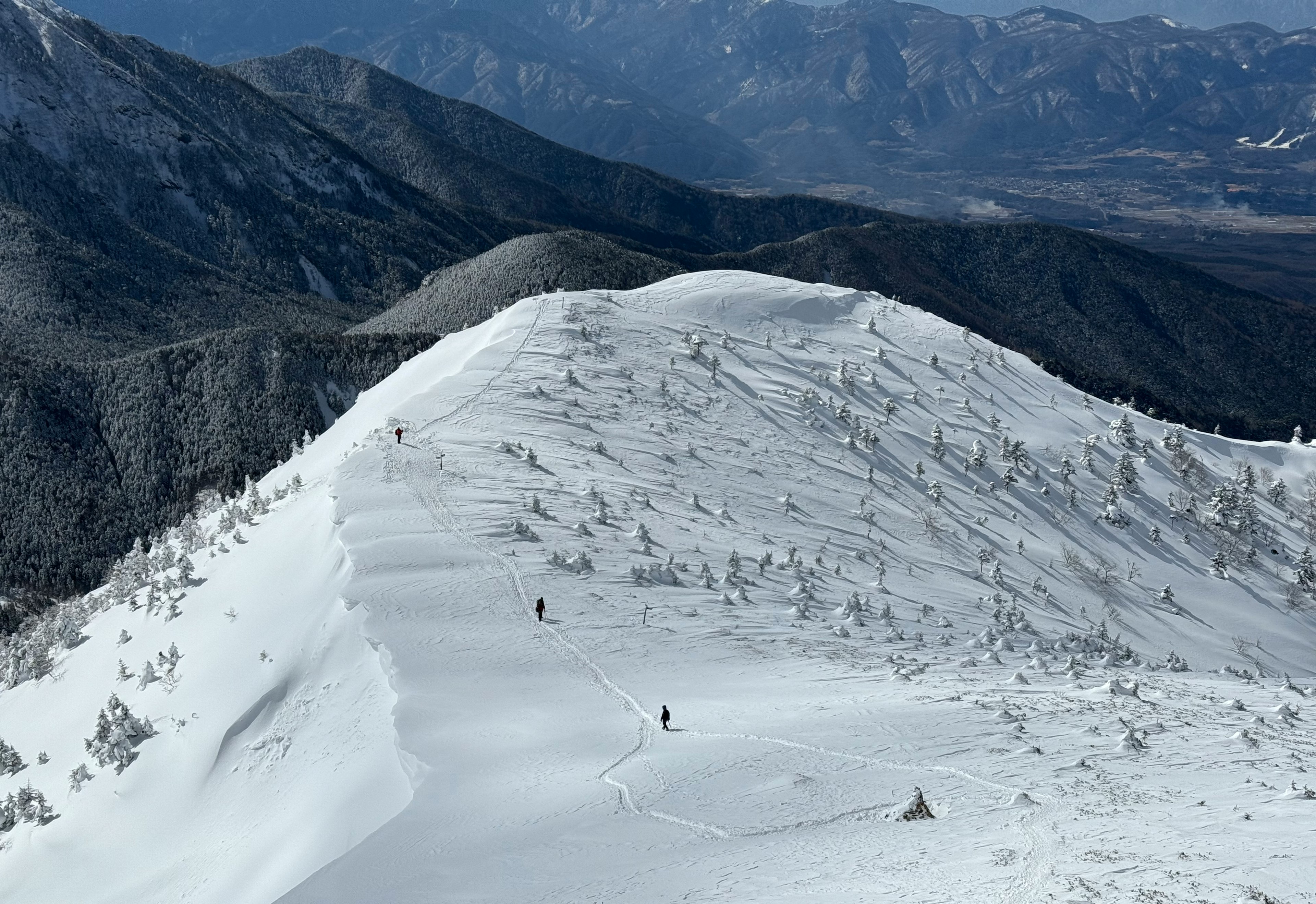 Cresta montañosa cubierta de nieve con picos distantes