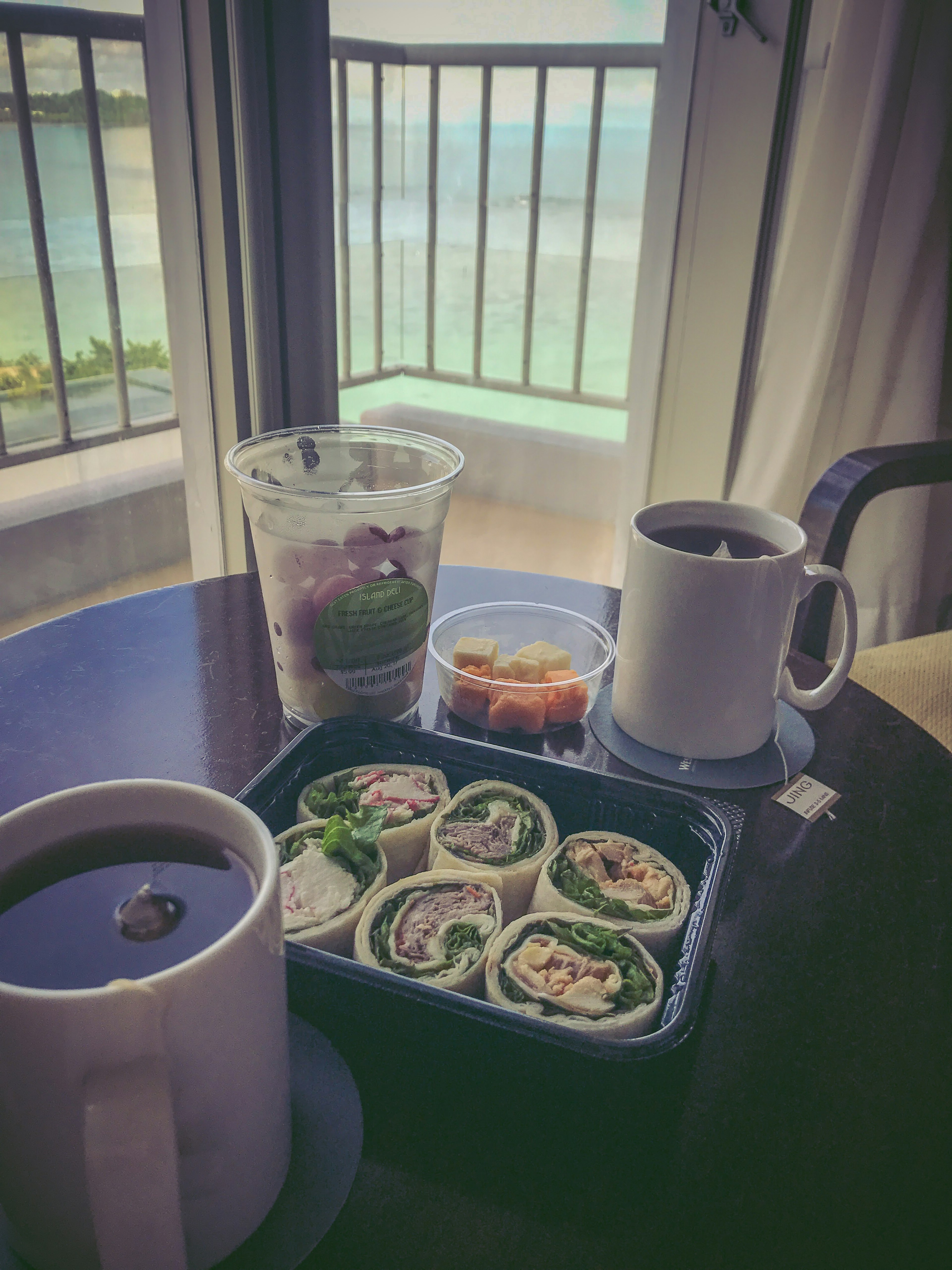 Sushi y café en una mesa con vista al mar de fondo