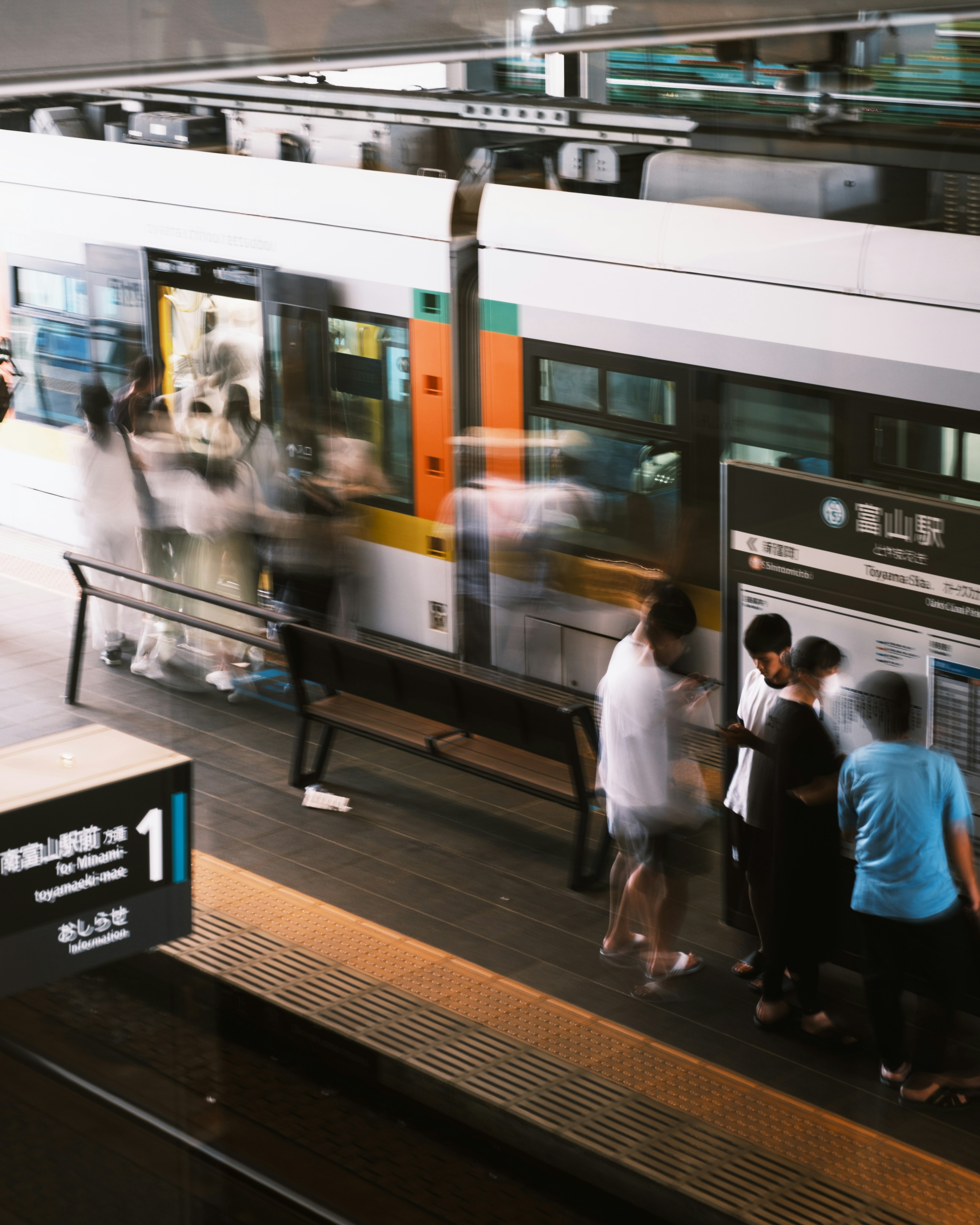 People waiting for a train on a platform with blurred motion in the background