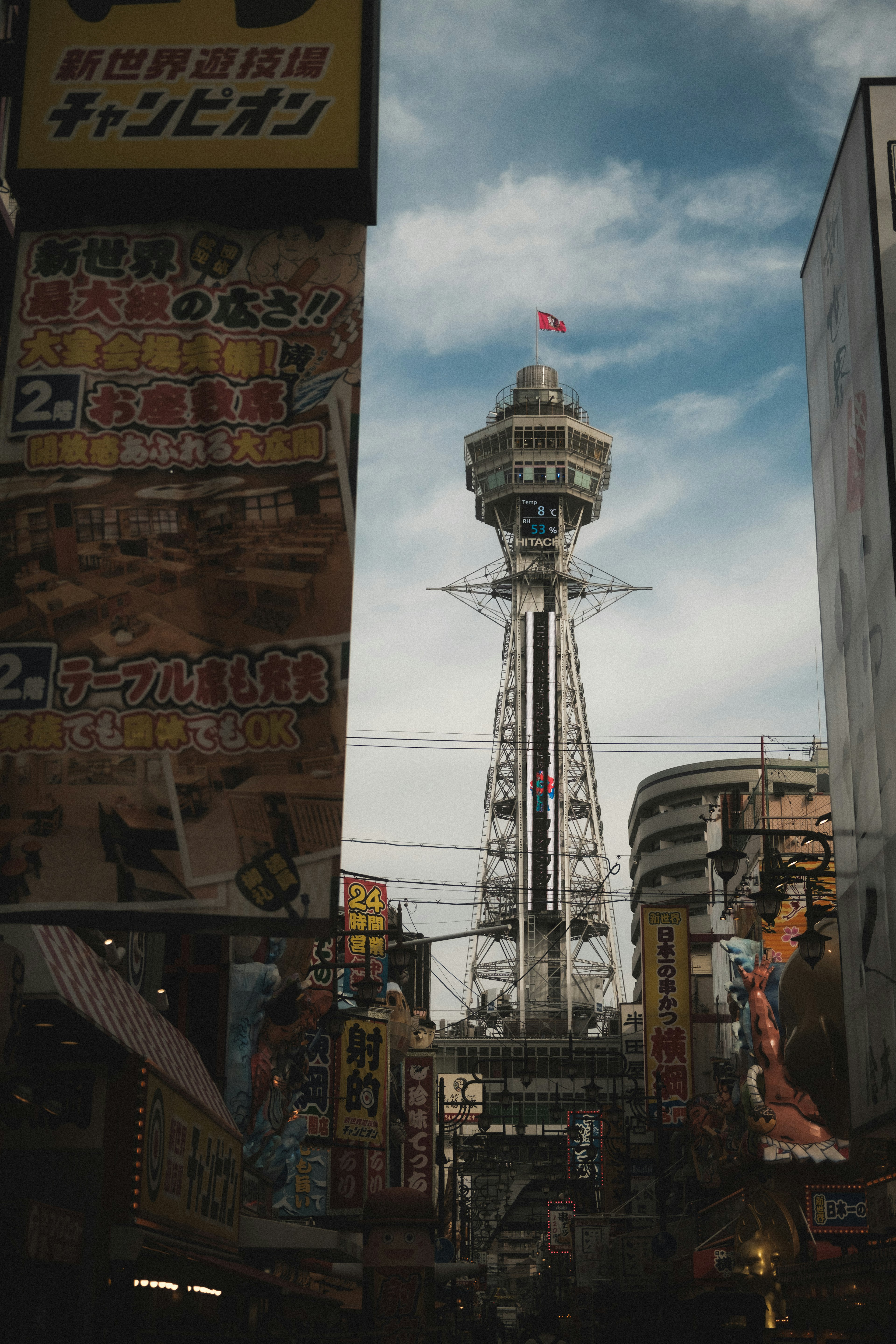 La tour Tsutenkaku se dressant dans la rue Dotonbori avec des bâtiments environnants