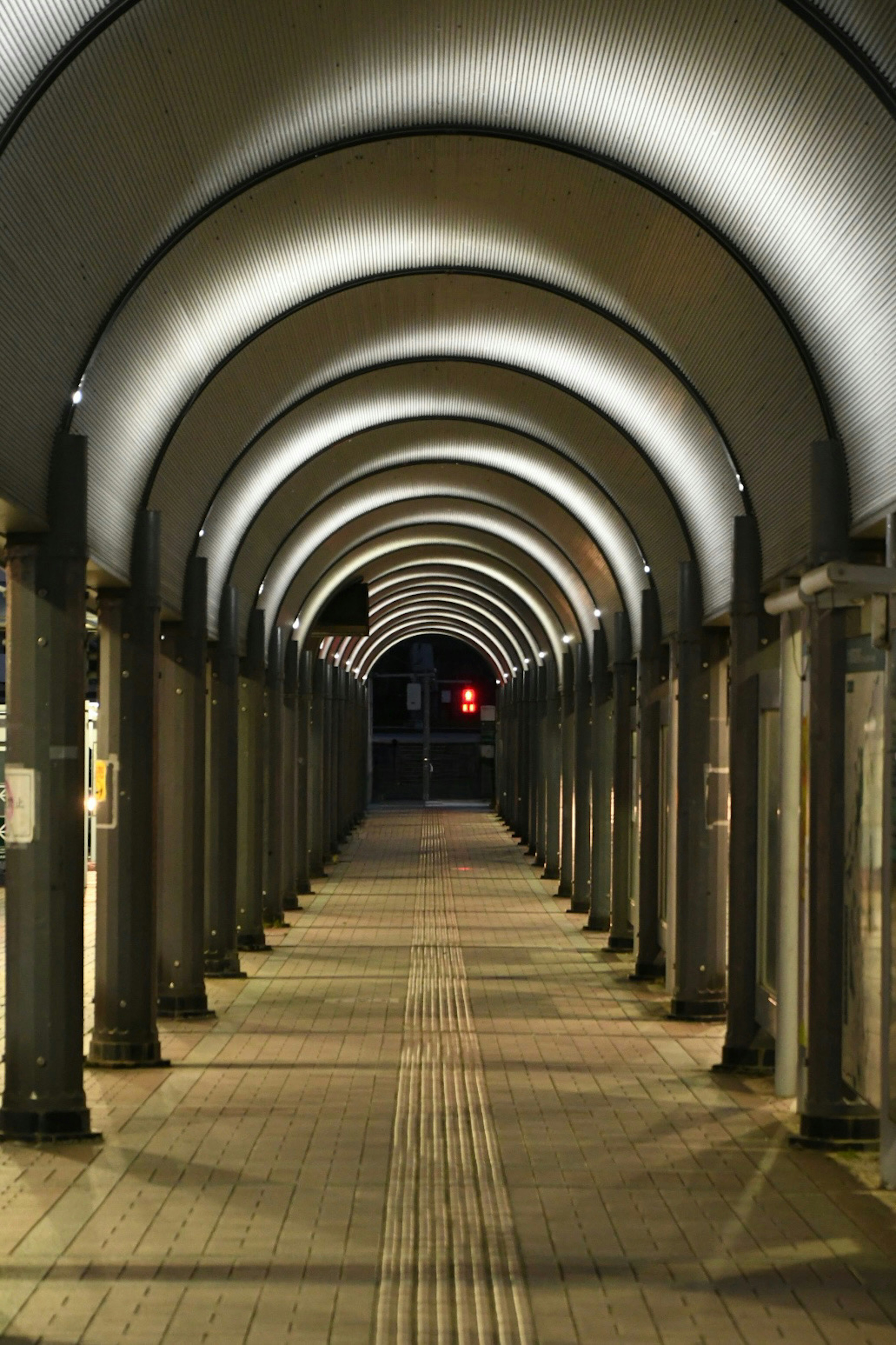 照明が施されたアーチ型の通路が続く夜の風景