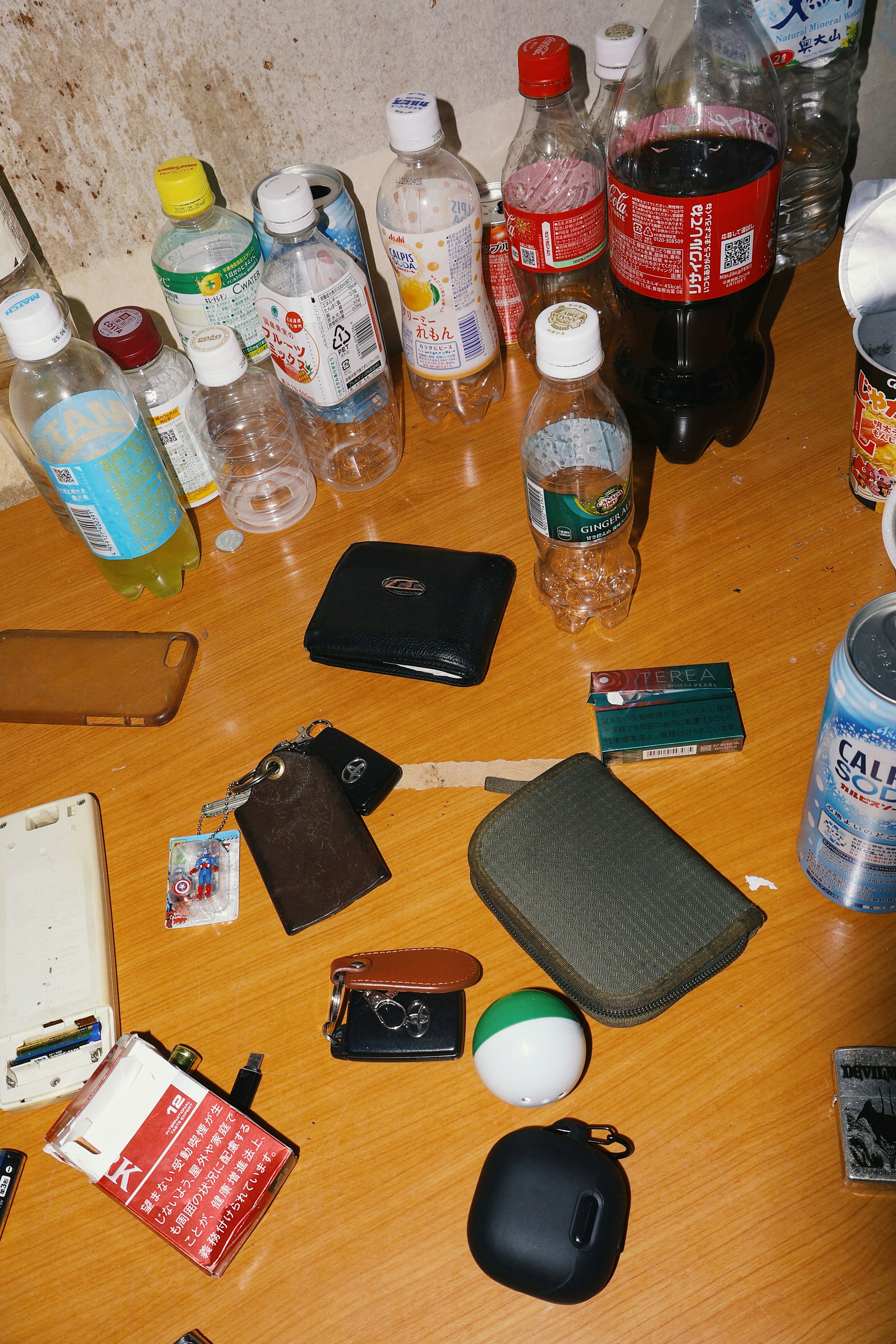 A collection of various items and beverage bottles scattered on a table