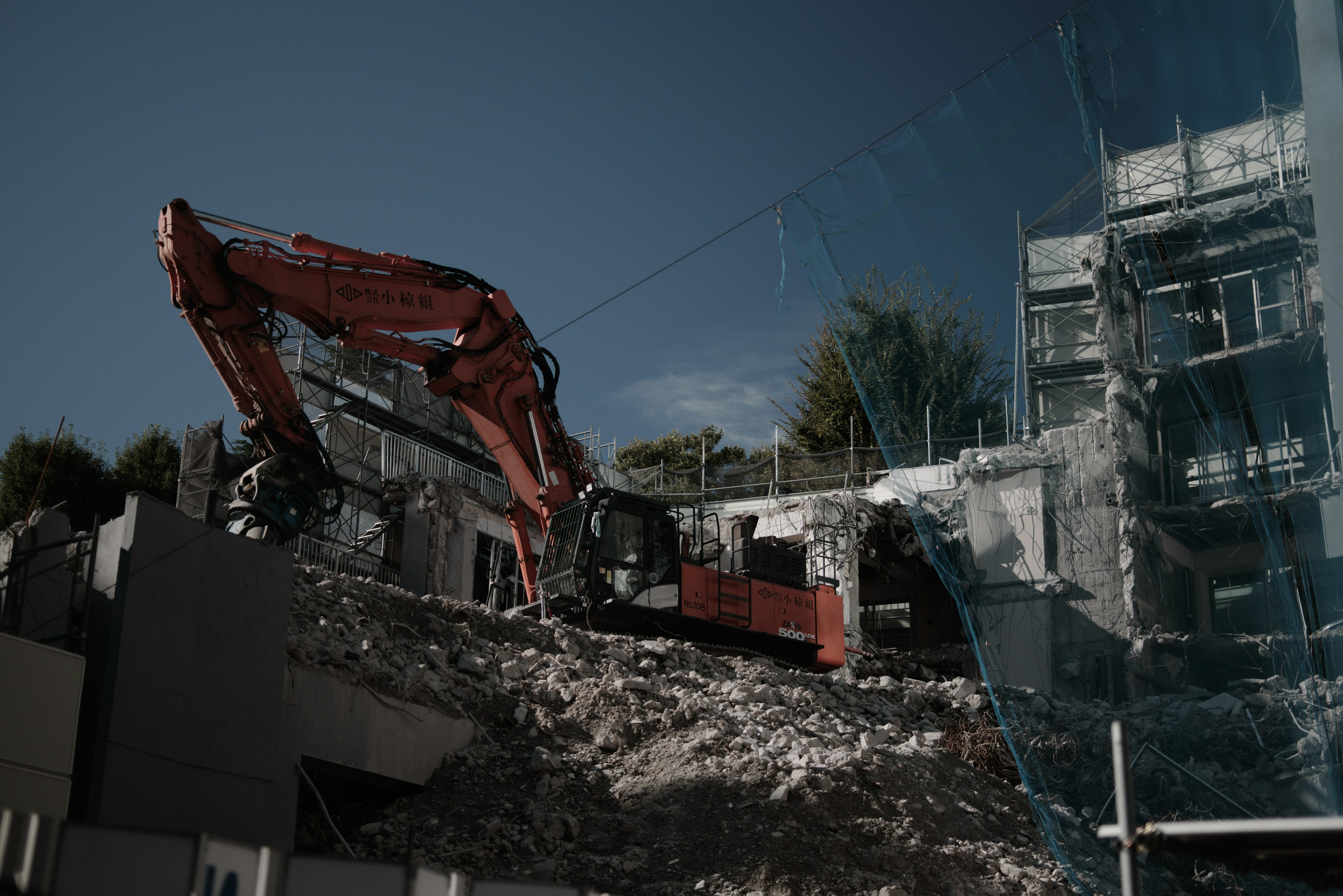 Excavator demolishing a building at a construction site