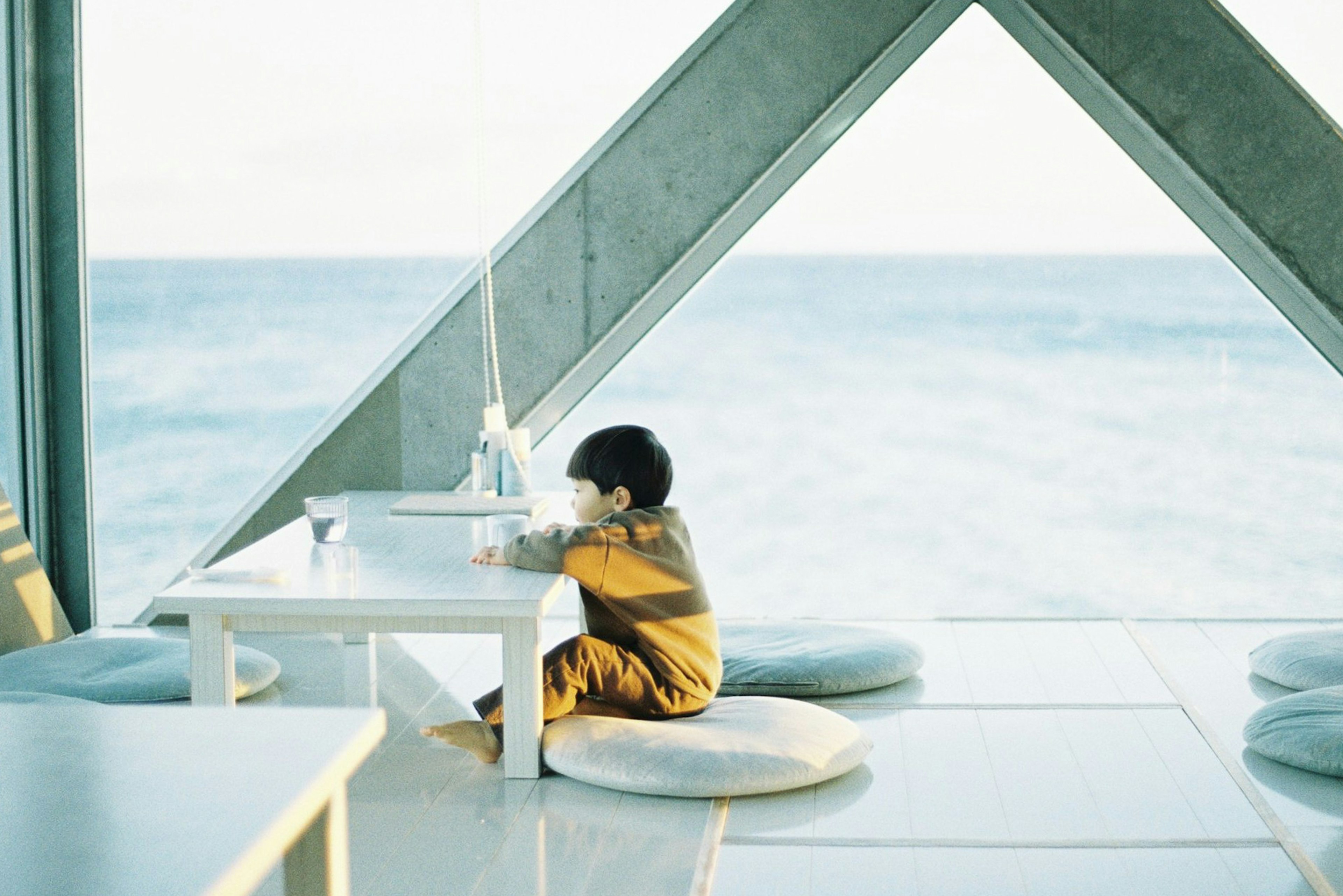 Child sitting in a cafe with ocean view