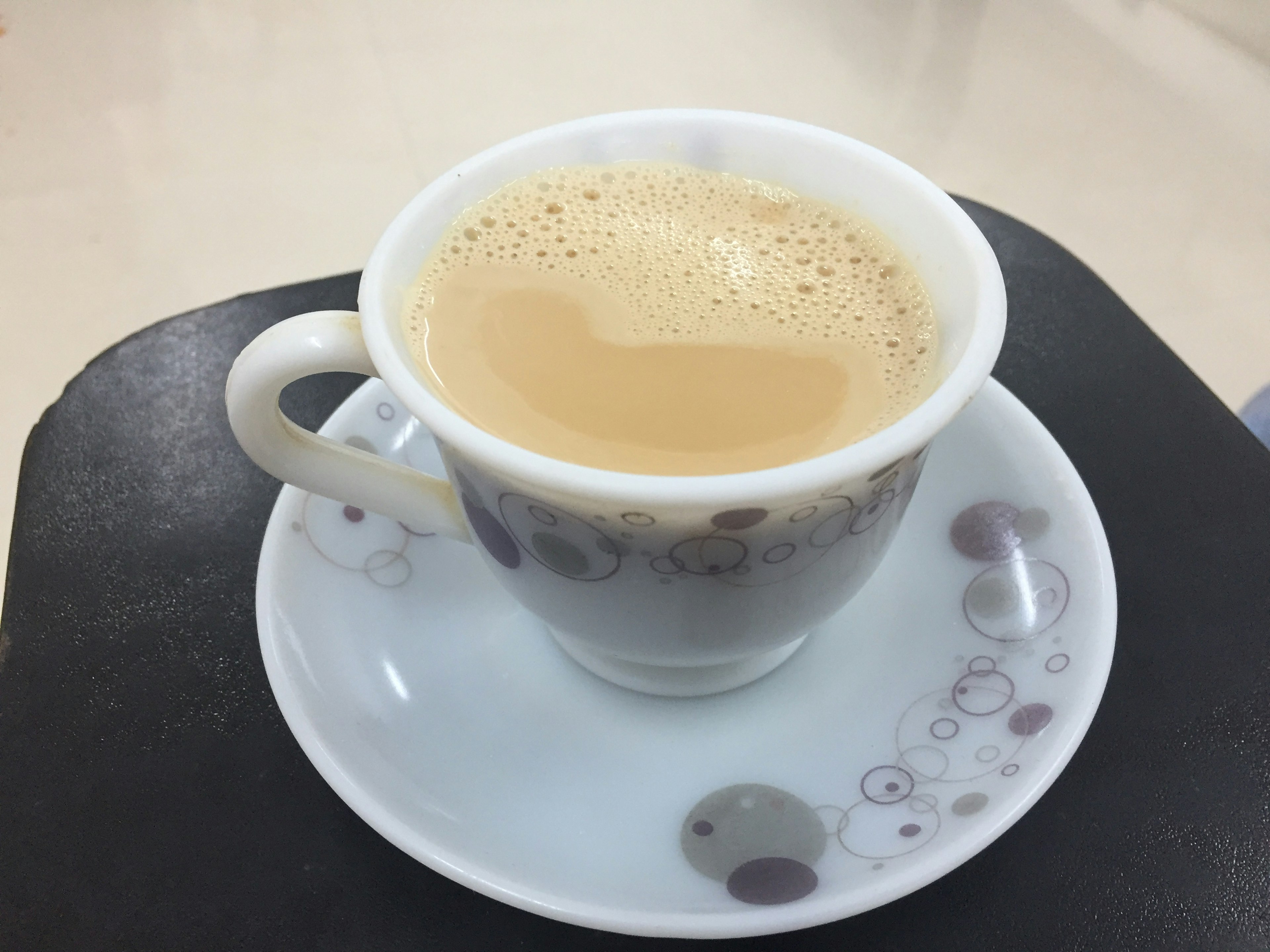 Café crémeux dans une tasse blanche avec sous-tasse