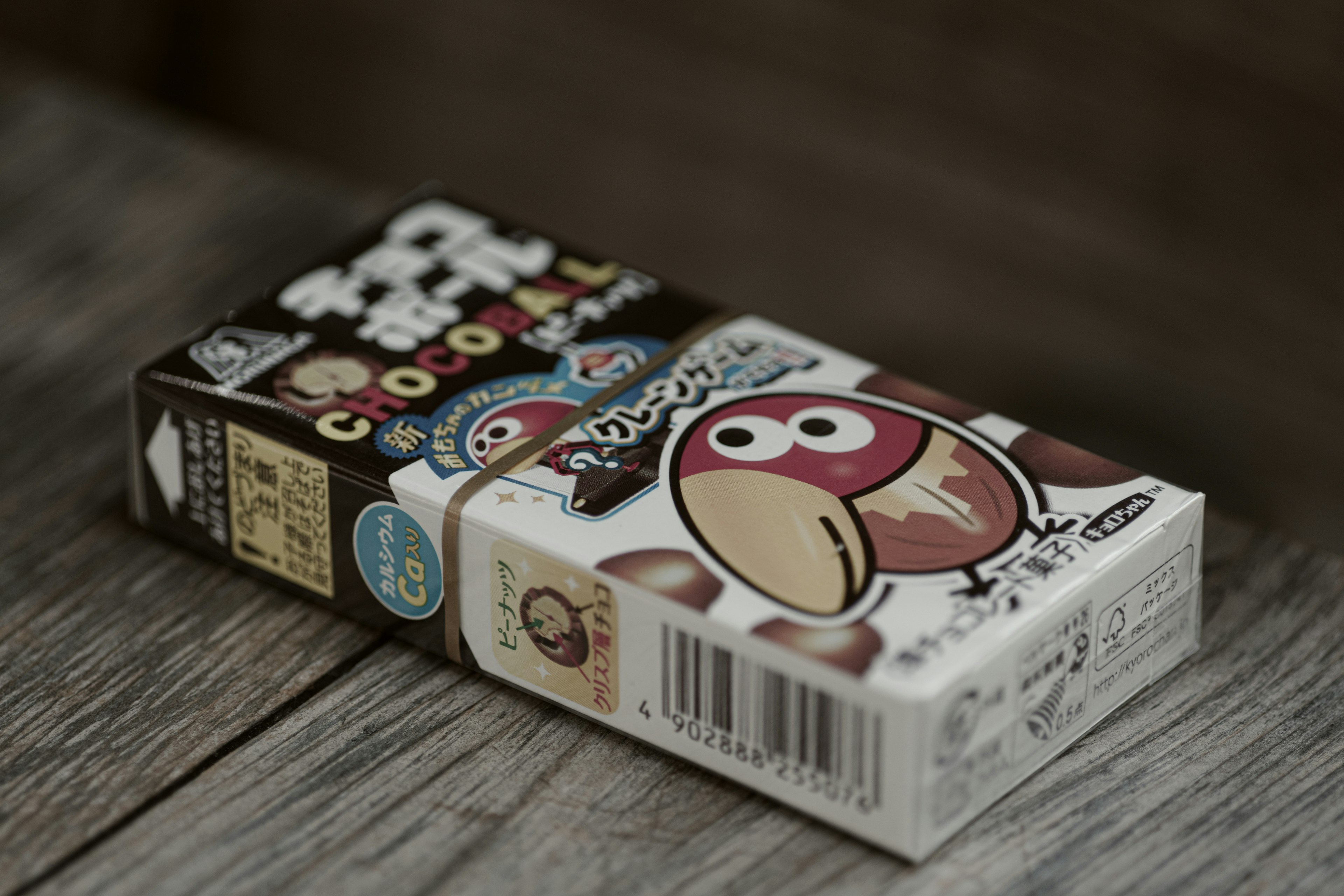 A cute chocolate packaging featuring a character design placed on a wooden table