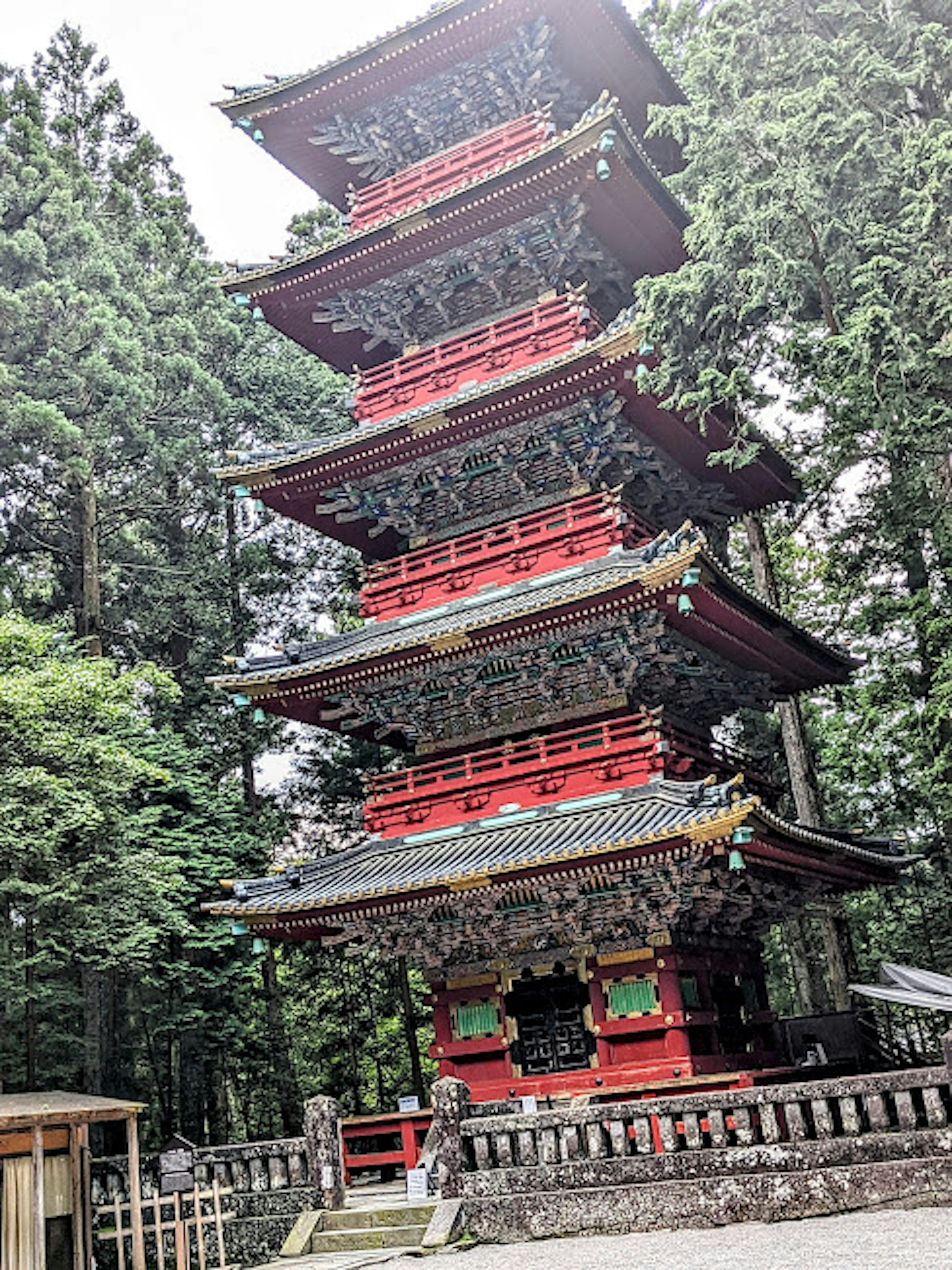 Pagode rouge à cinq étages entourée d'arbres verts