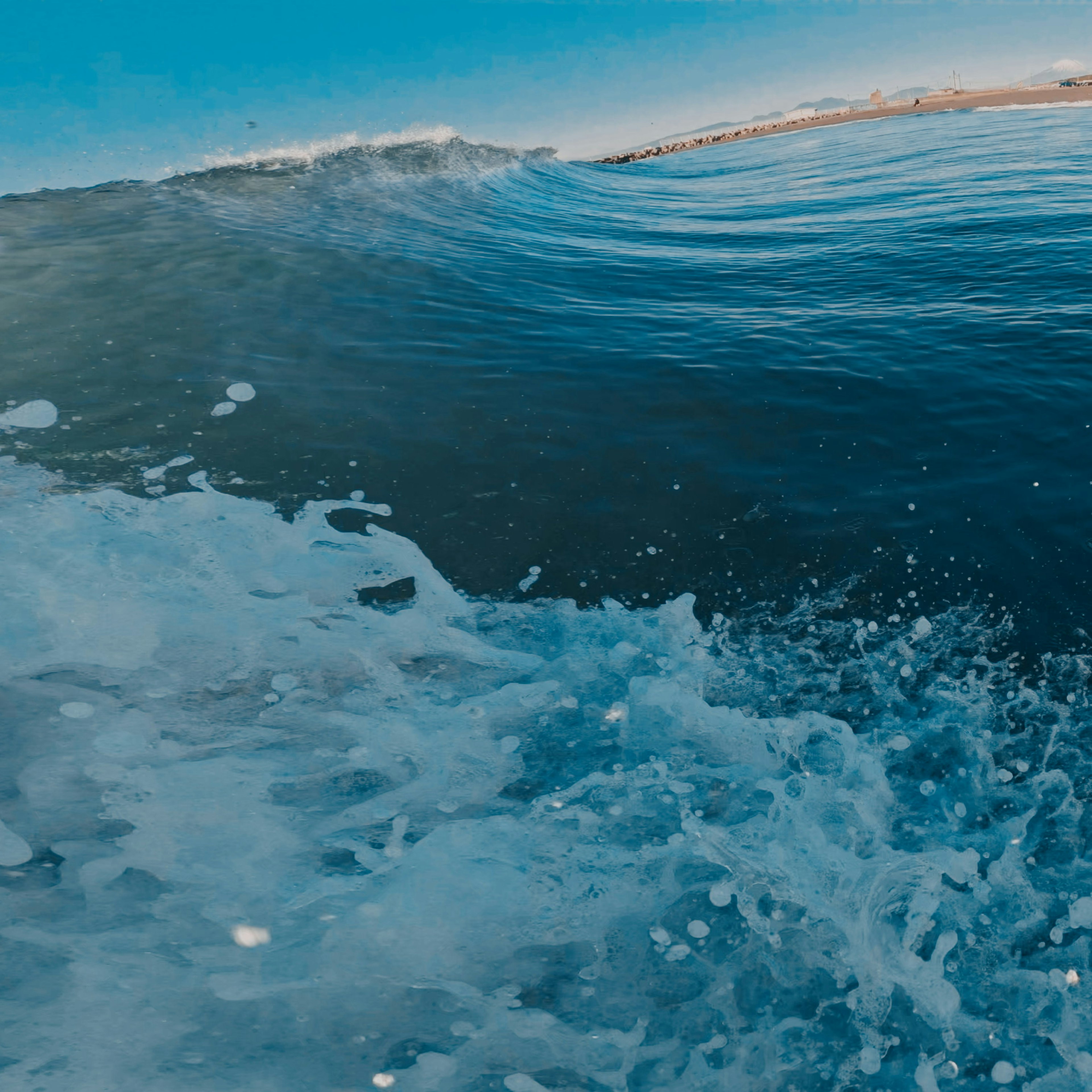 波の上での青い海と白い泡の詳細