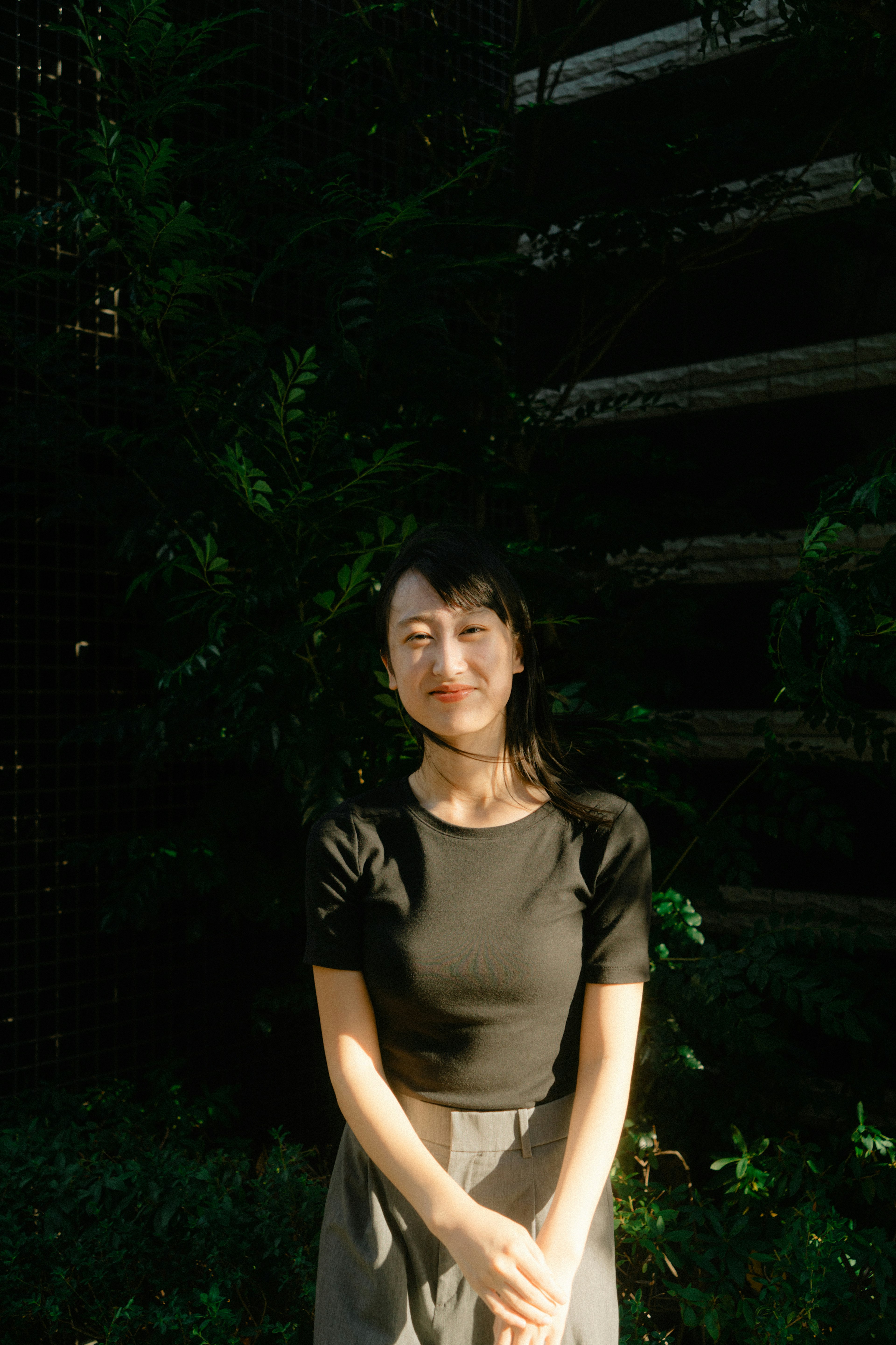 A woman standing in front of a green background