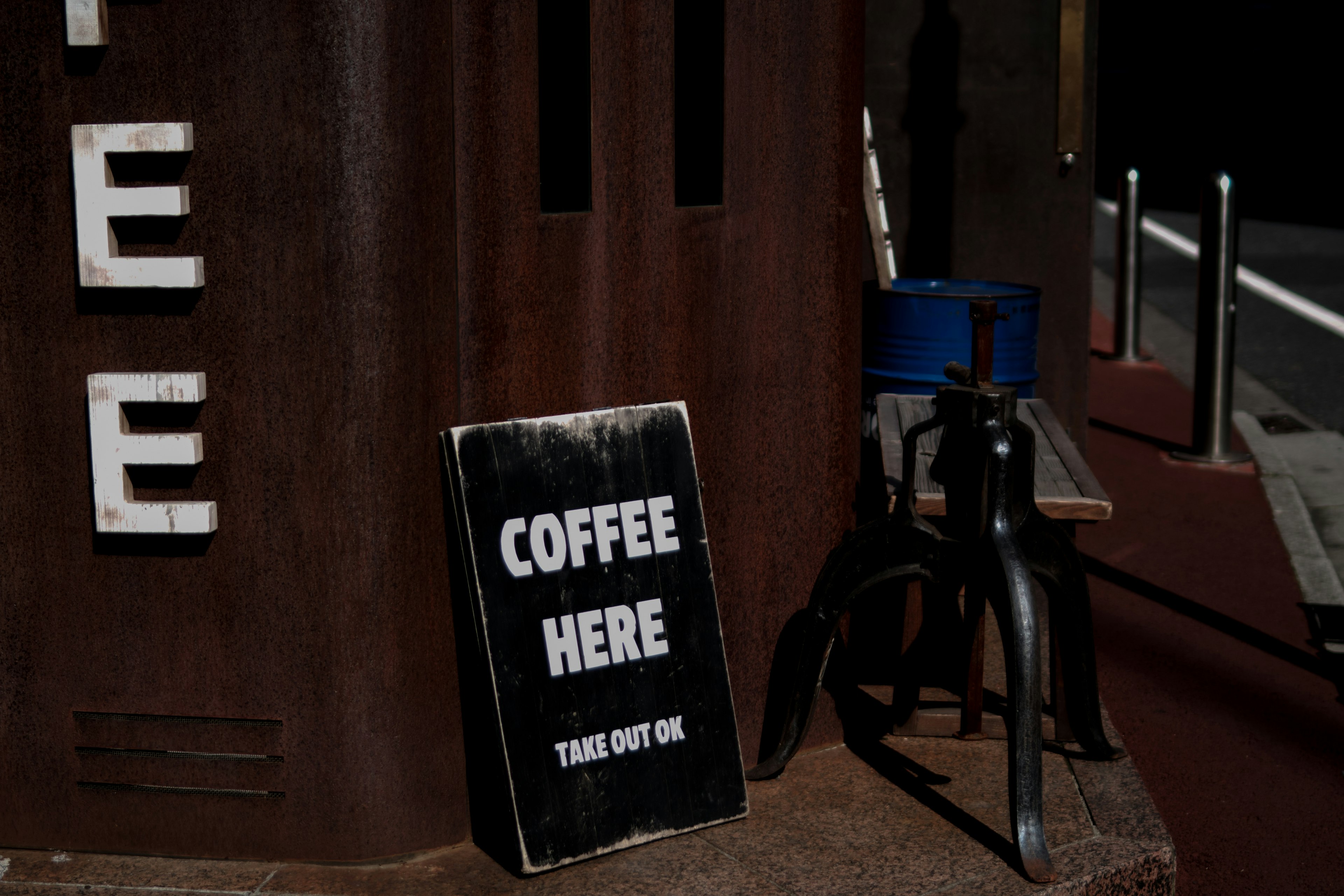 Cartel de café exhibido afuera de una cafetería