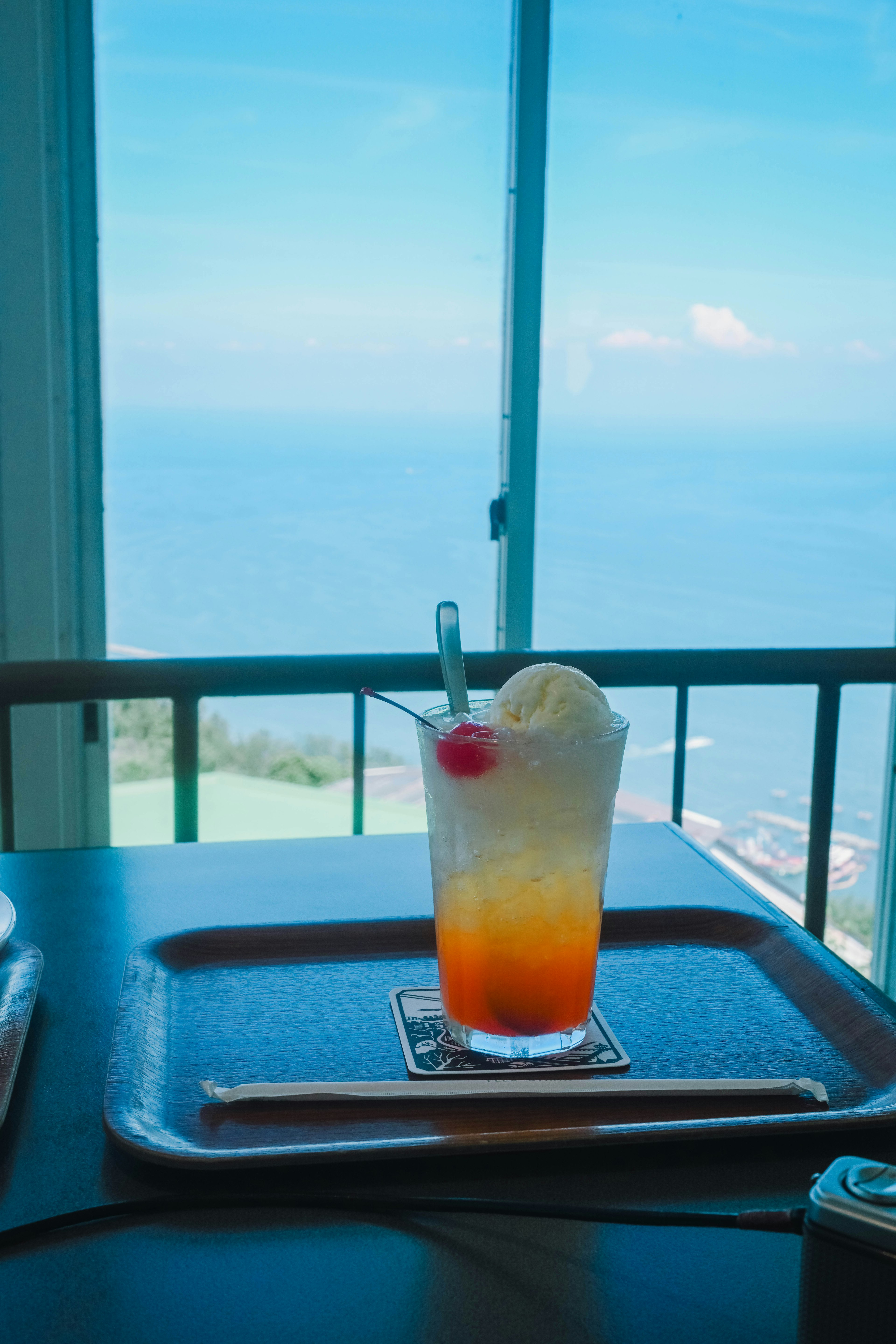 Verre de cocktail avec de la glace en arrière-plan d'une vue sur l'océan