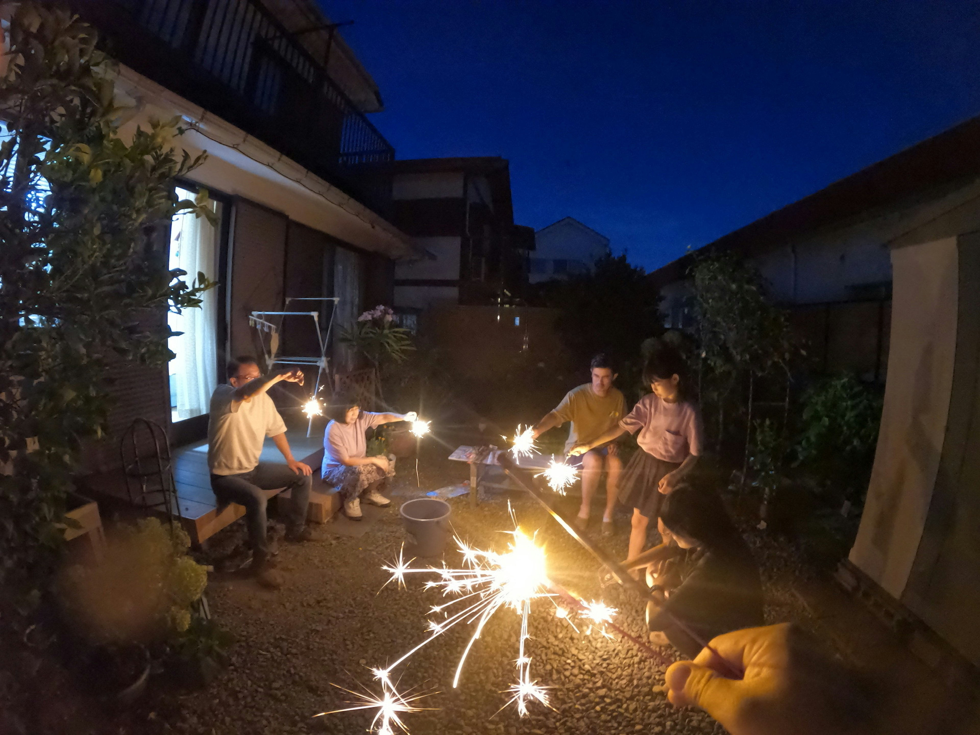 Rassemblement familial profitant des pétards dans un jardin la nuit