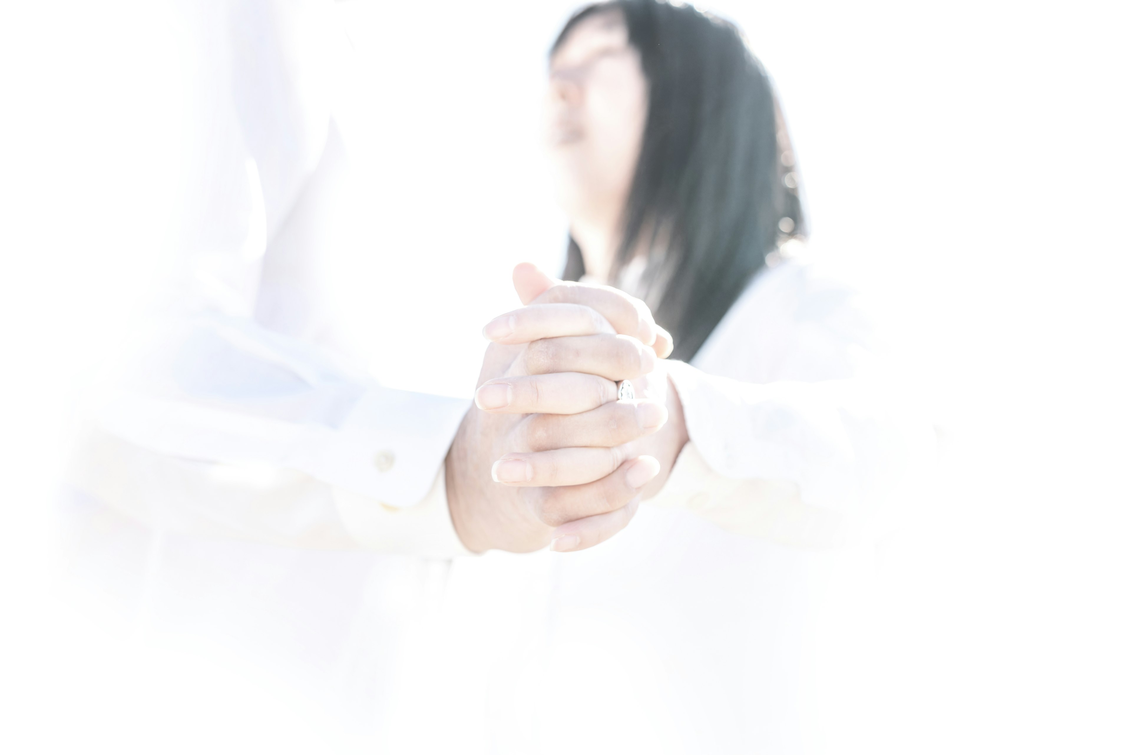 สองคนจับมือกันในพื้นหลังสว่าง