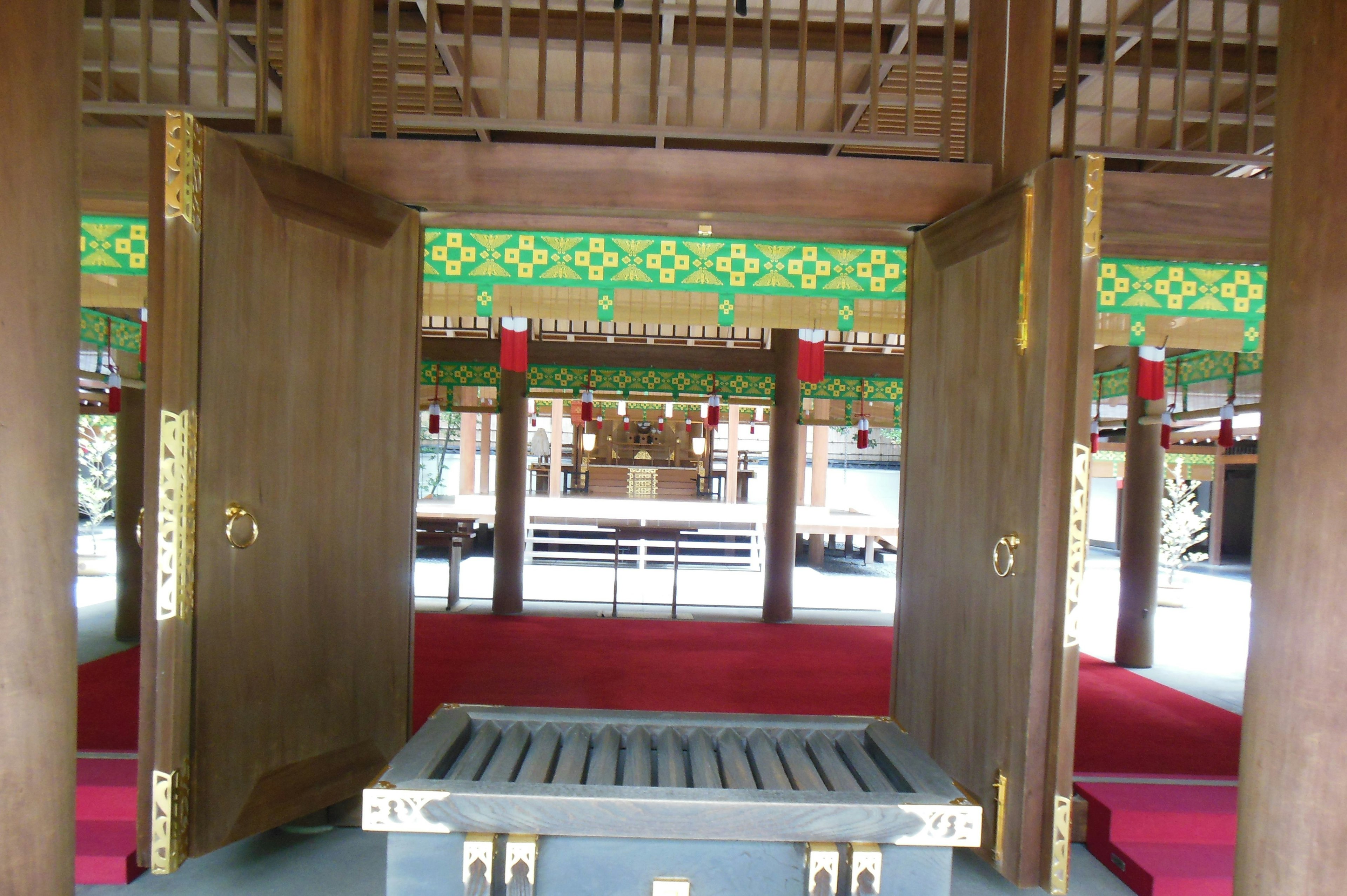 Interior view of a shrine with open doors red carpet and decorative elements