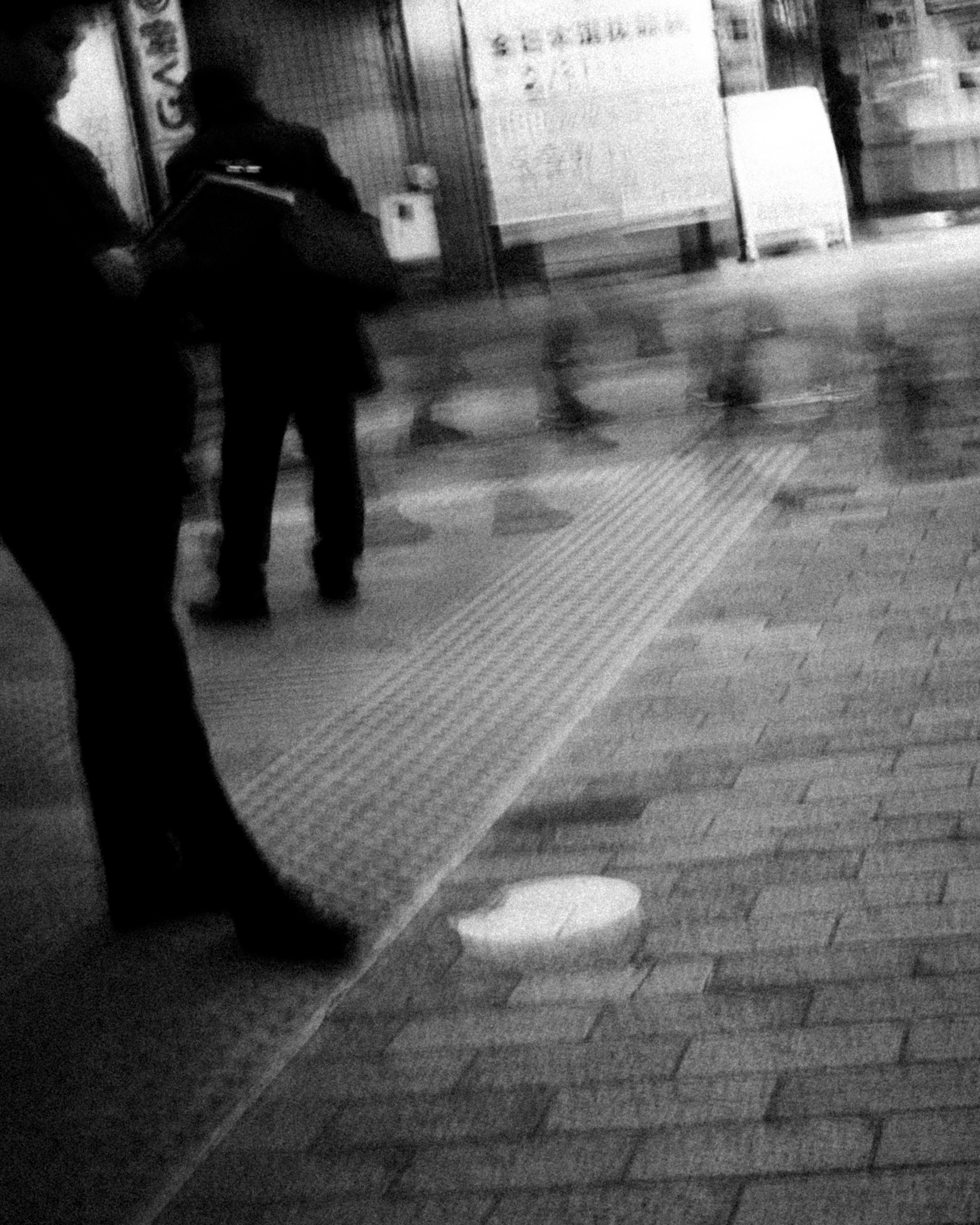 Escena urbana en blanco y negro con personas en movimiento