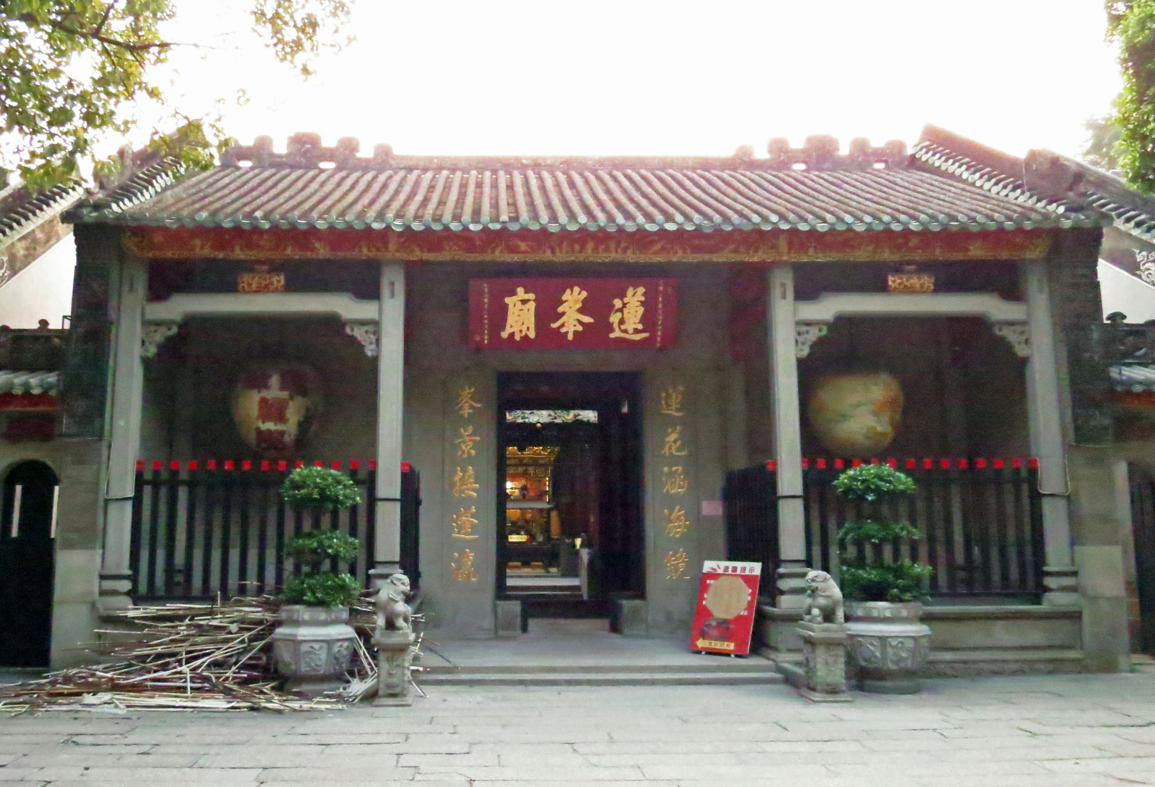 Entrée avant d'un ancien bâtiment chinois avec un panneau rouge et des décorations