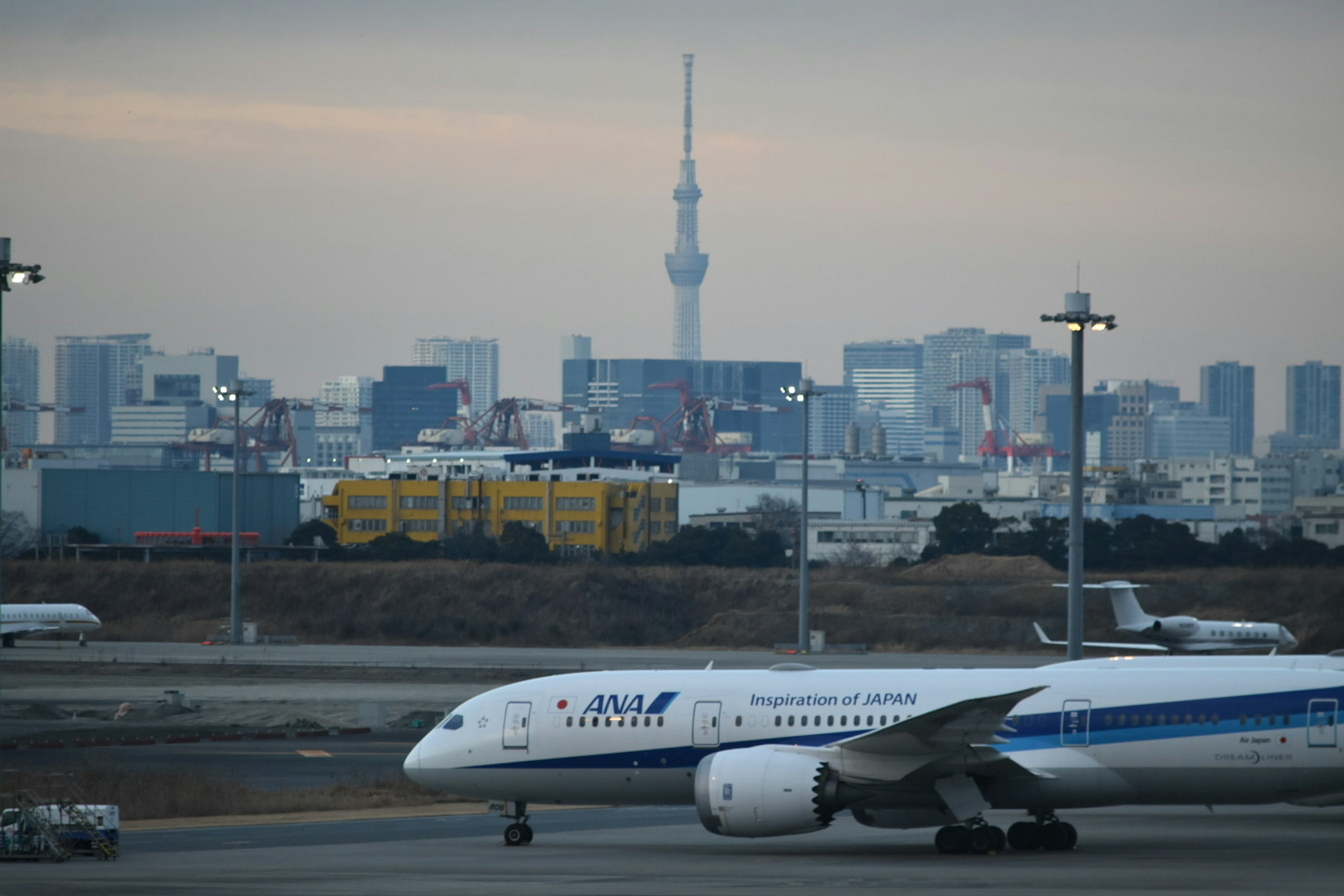 跑道上的飛機和背景中的東京天空樹