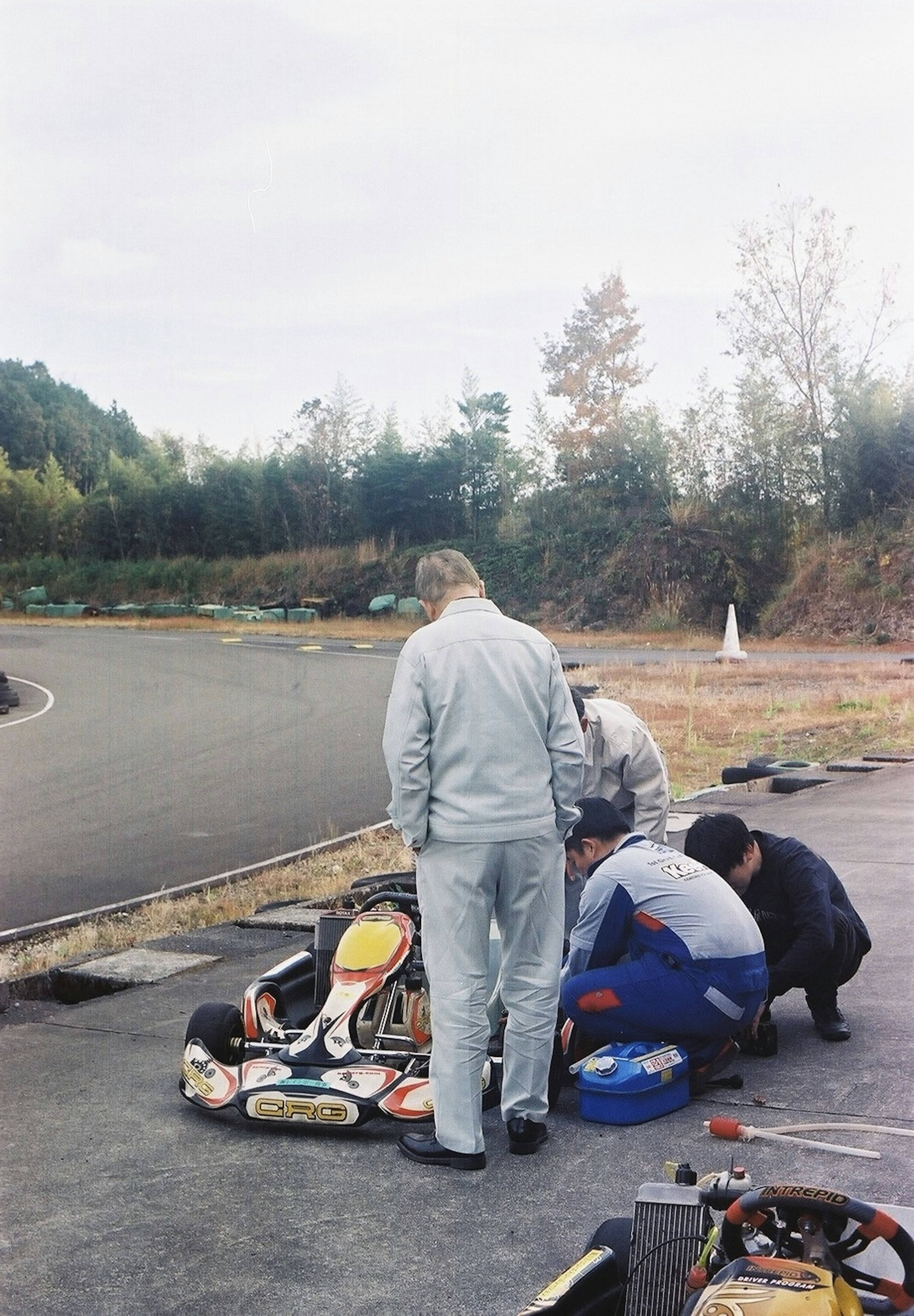 Group of people working on a go-kart in a racing environment