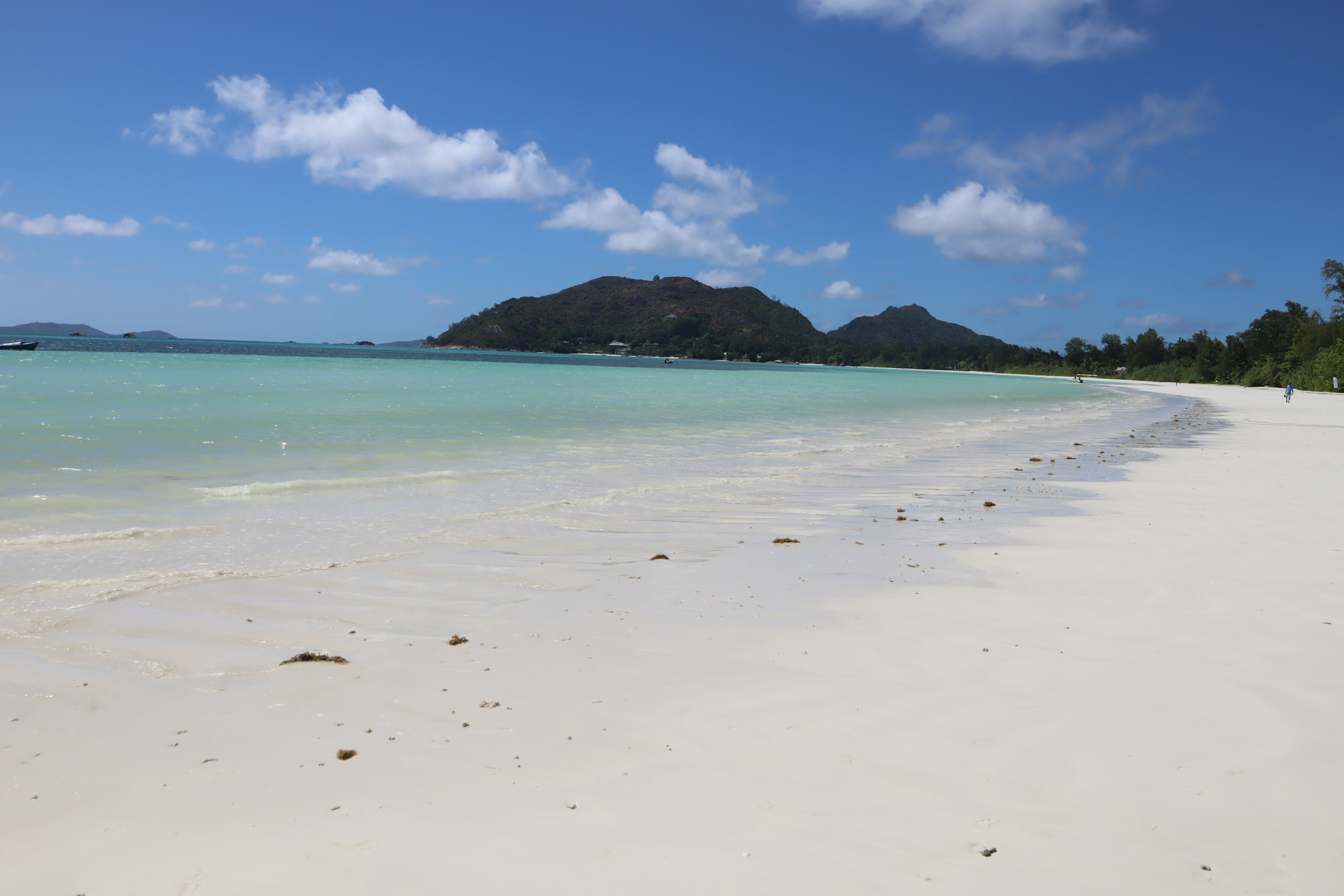 ทิวทัศน์ชายหาดที่สวยงามพร้อมทะเลสีน้ำเงินและชายฝั่งทรายขาว