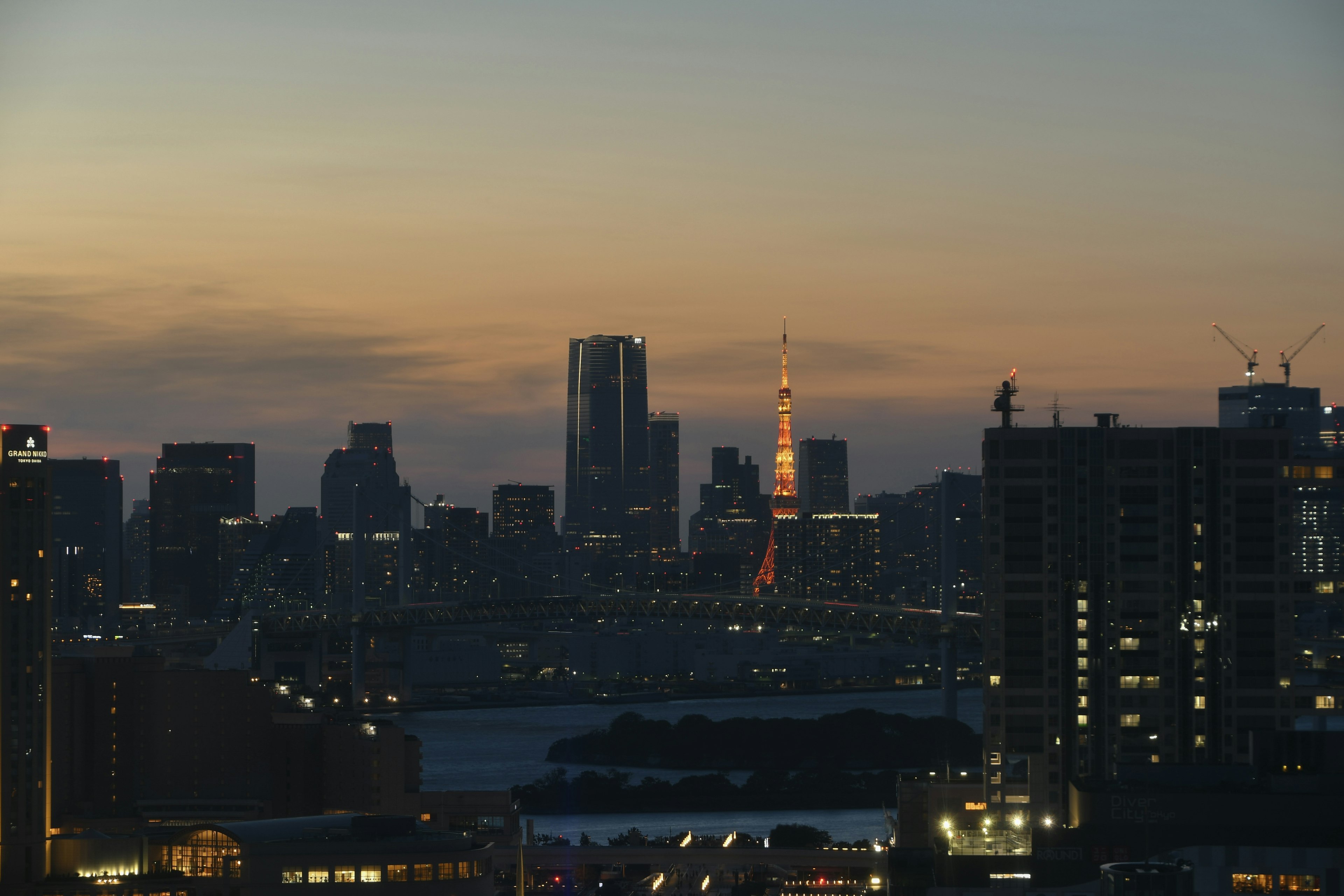 東京の夕暮れ時のスカイラインに東京タワーが見える