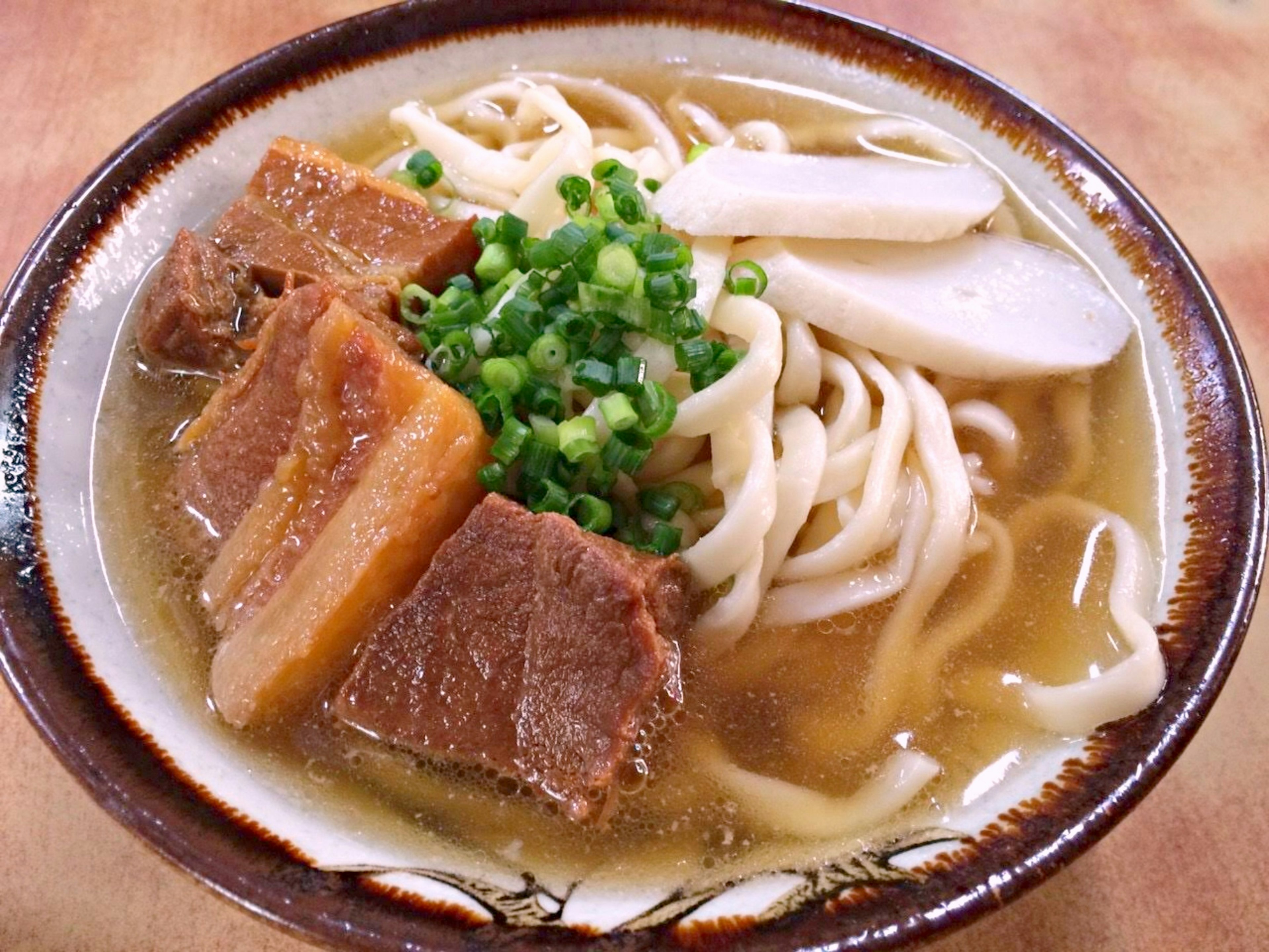 얇게 썬 돼지고기와 파가 얹힌 맛있는 라면 한 그릇