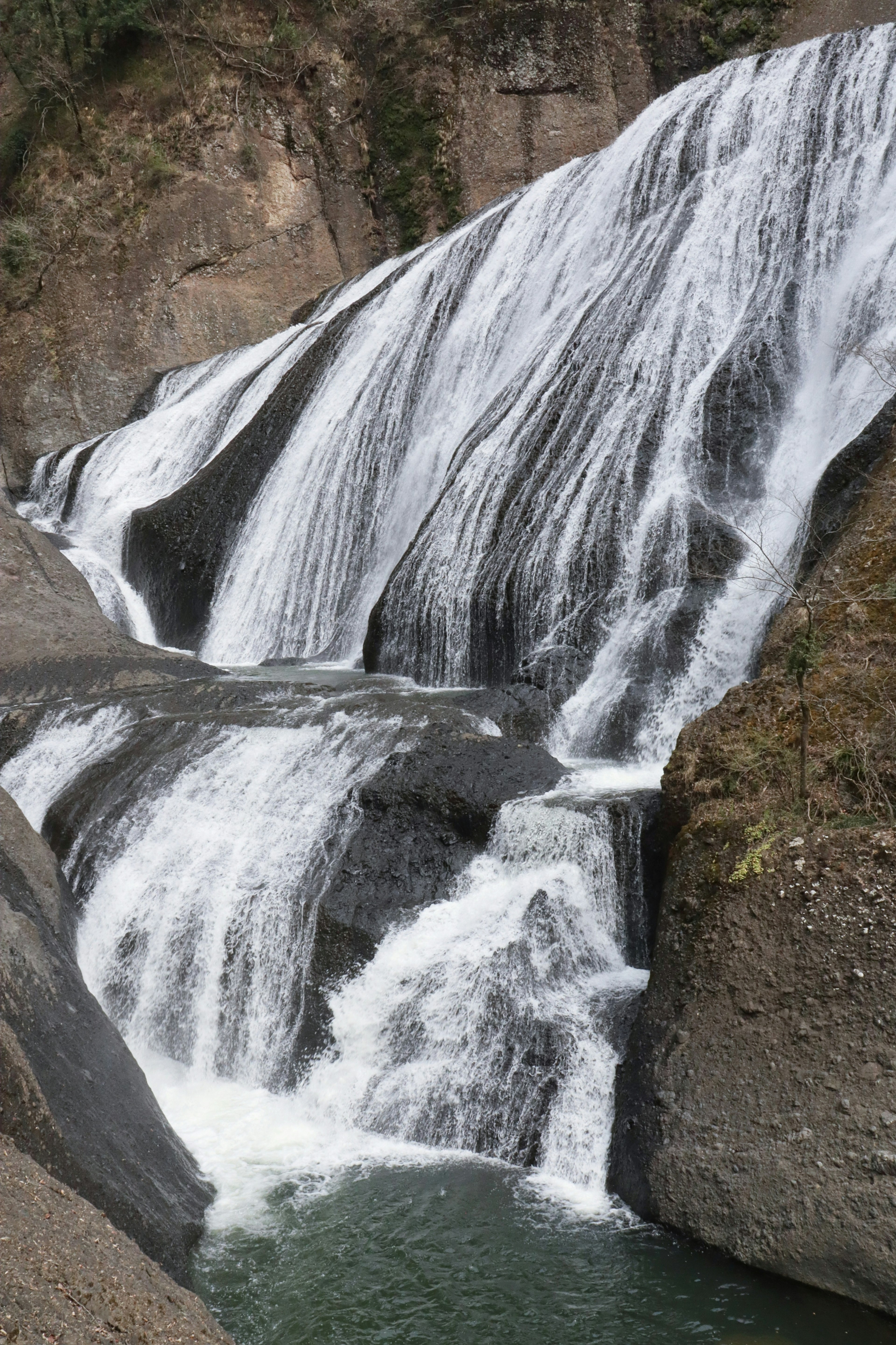 Bild eines Wasserfalls, der über felsiges Gelände fließt