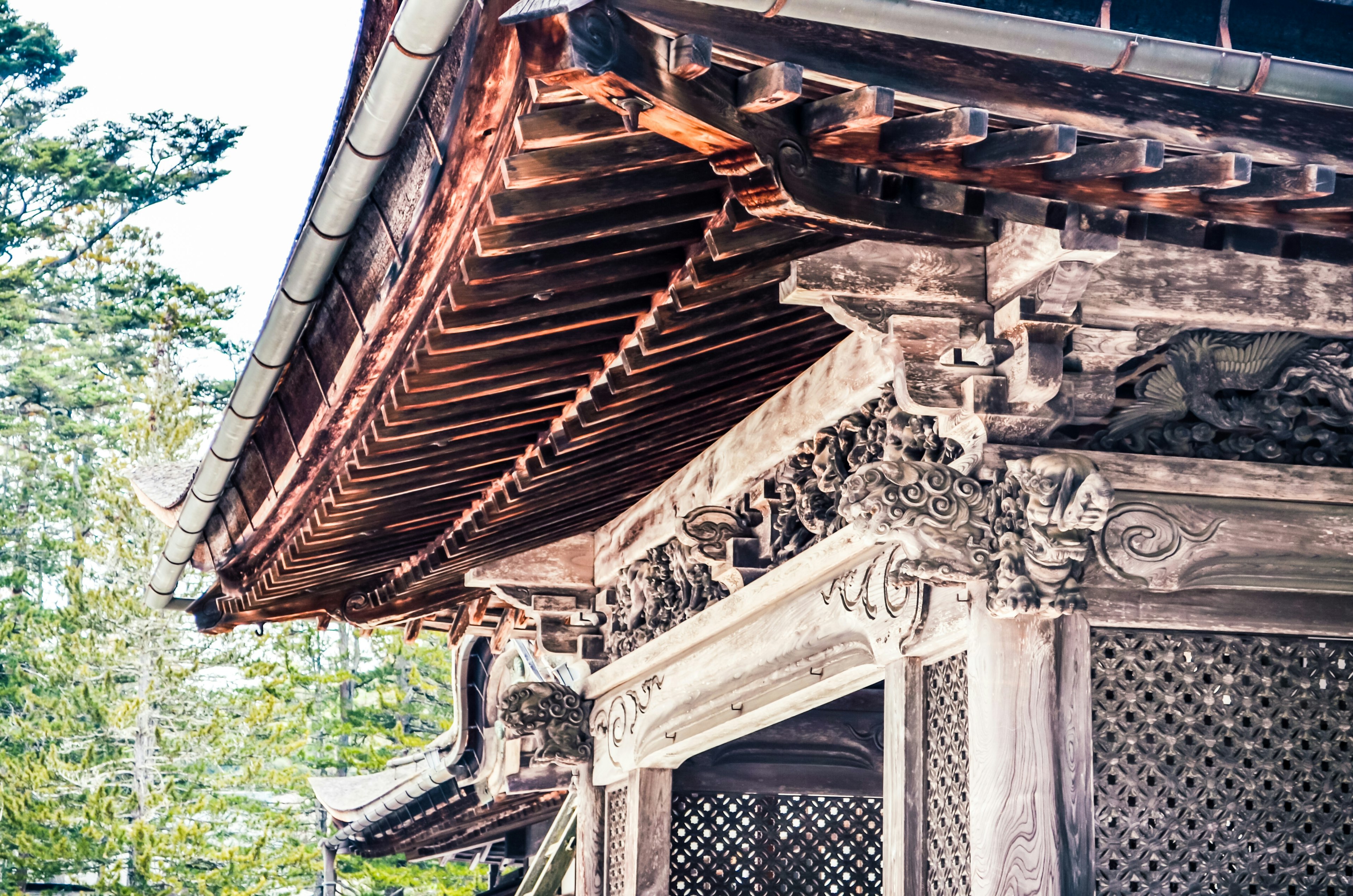 Detailed view of a beautiful wooden building roof showcasing intricate carvings and traditional design